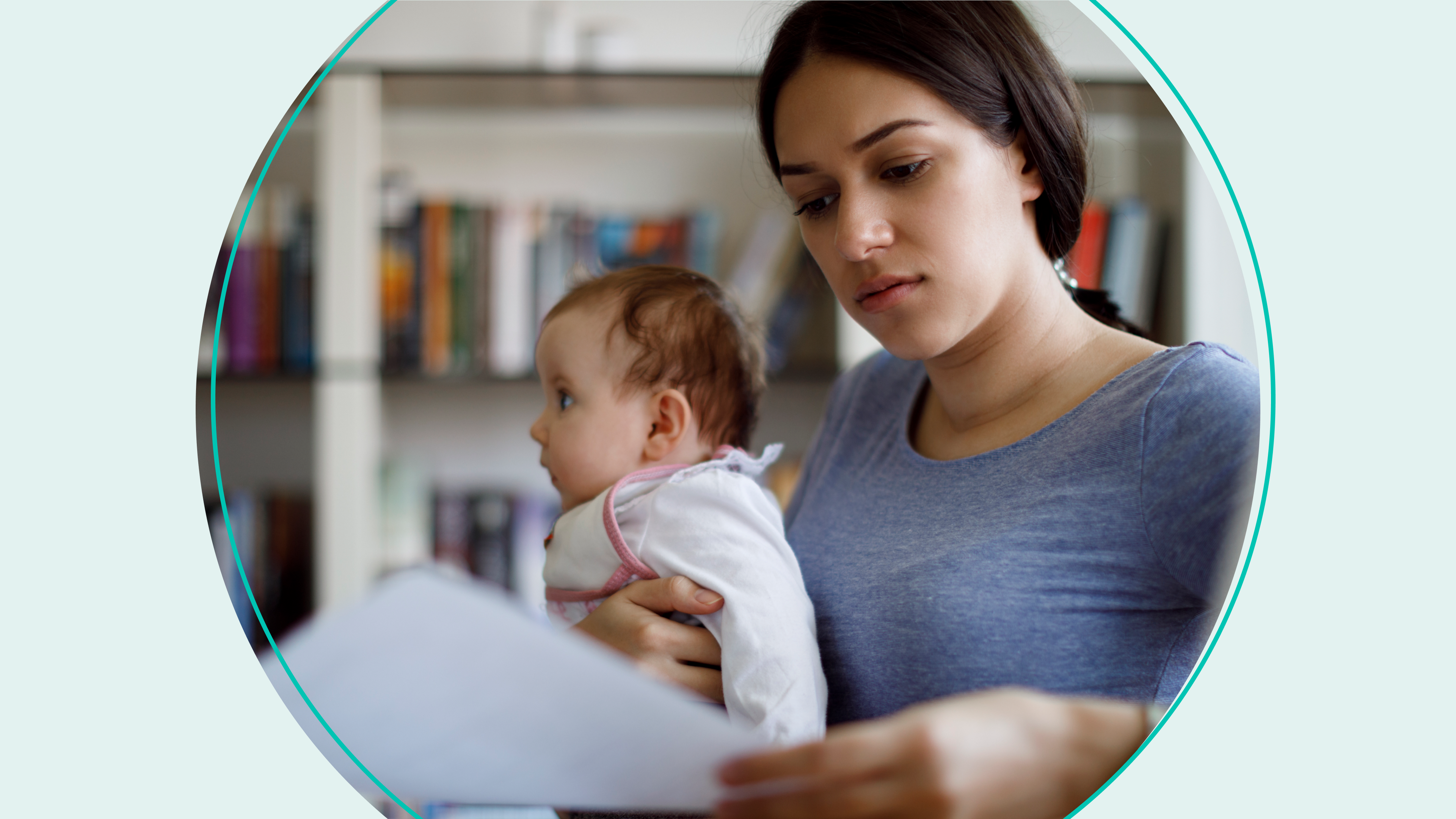 woman holding baby in one hand and reading a piece of paper with the other