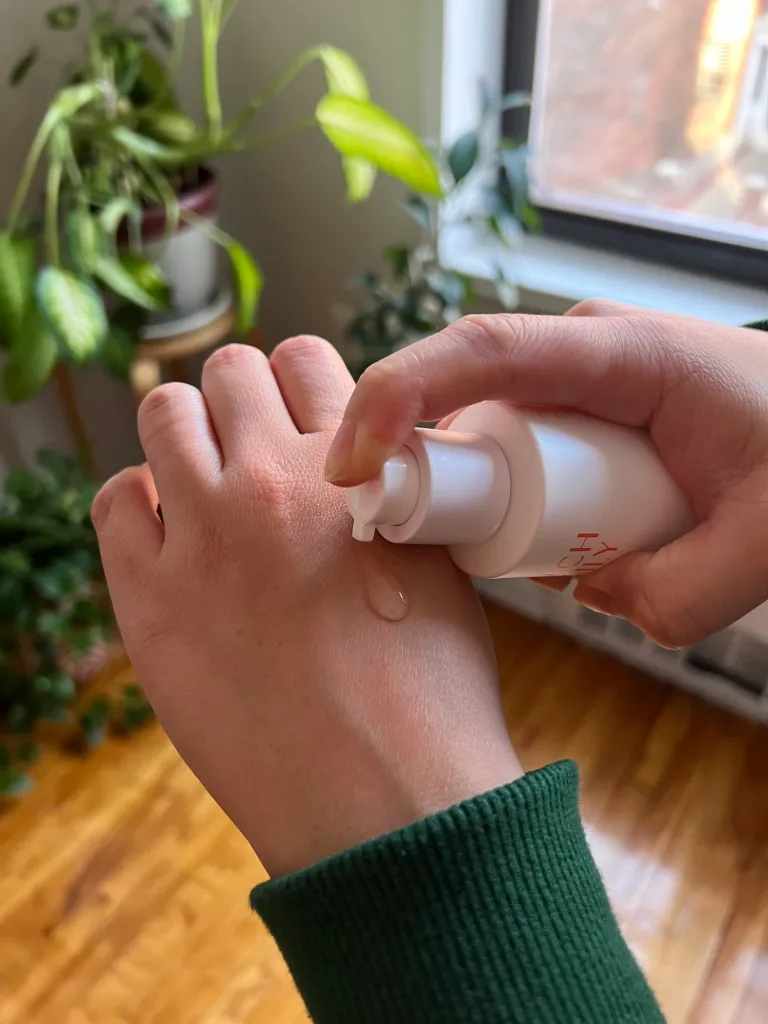 Woman pumping serum onto back of hand