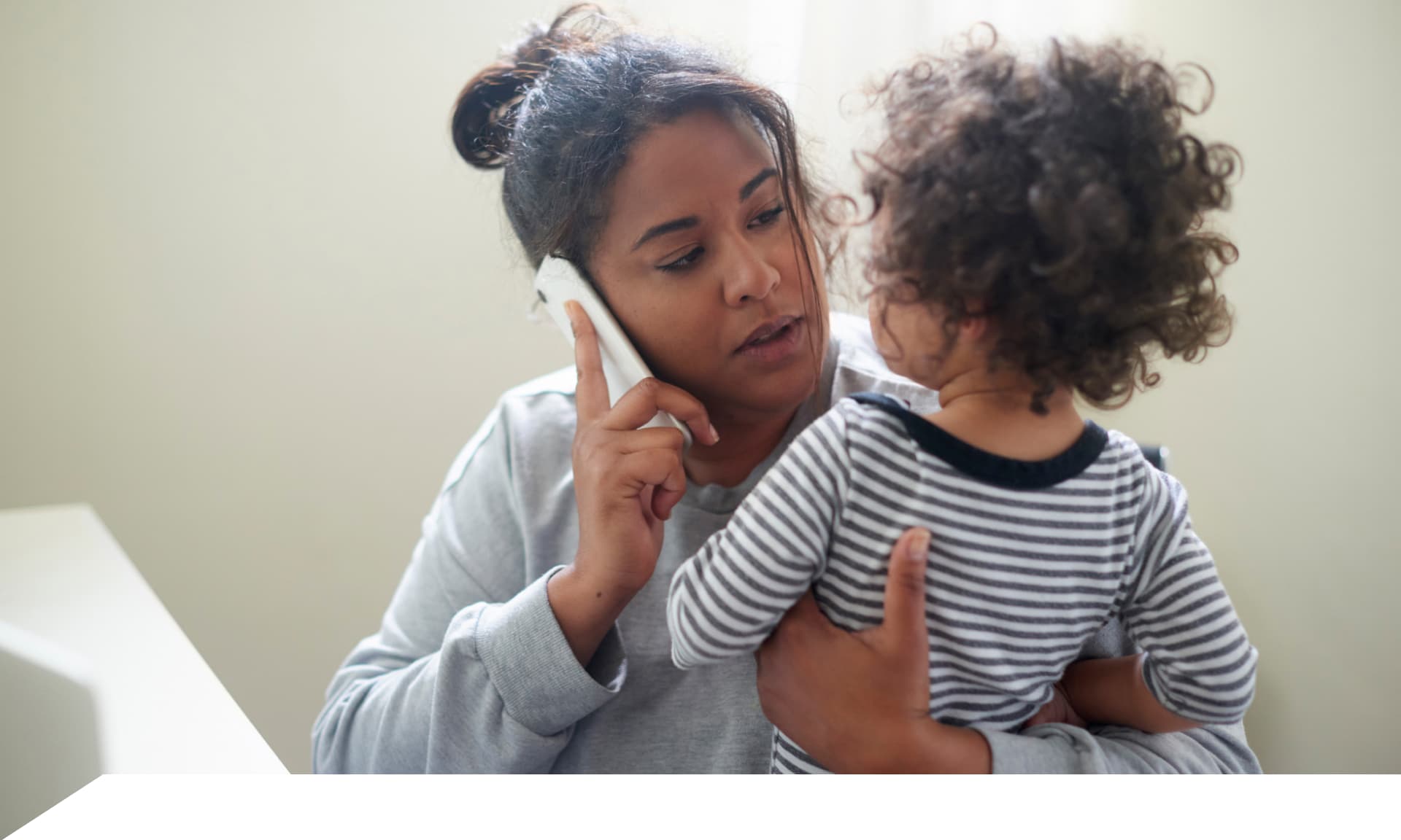 mom on the phone while holding child