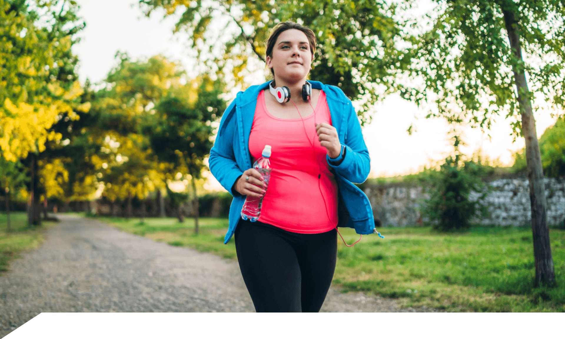 A woman walking in a park wearing workout clothes