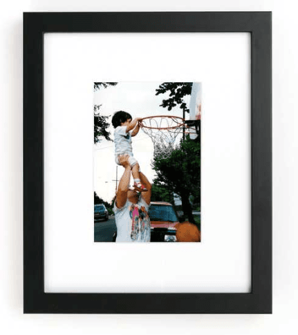 Framed photo of dad holding up son to dunk basketball