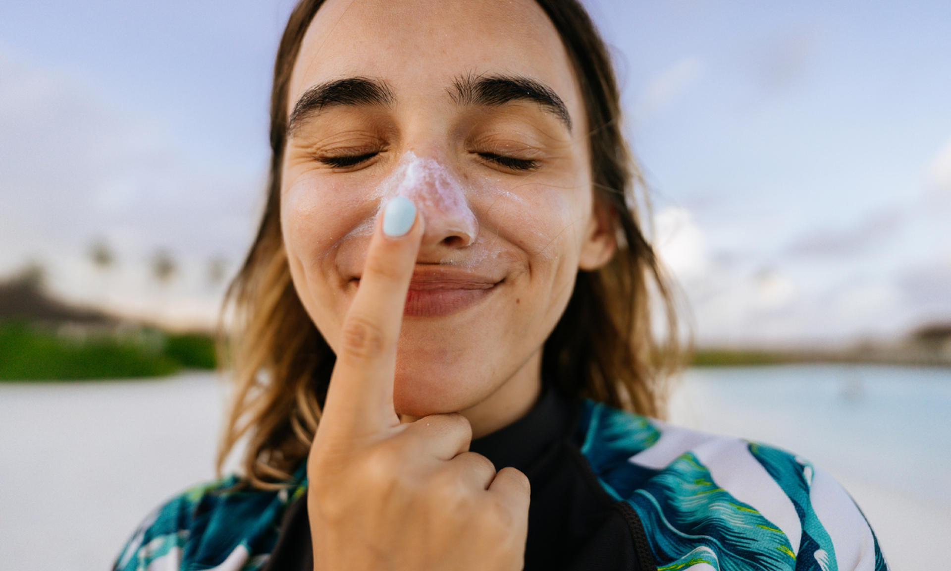 Woman applying sunscreen on her nose