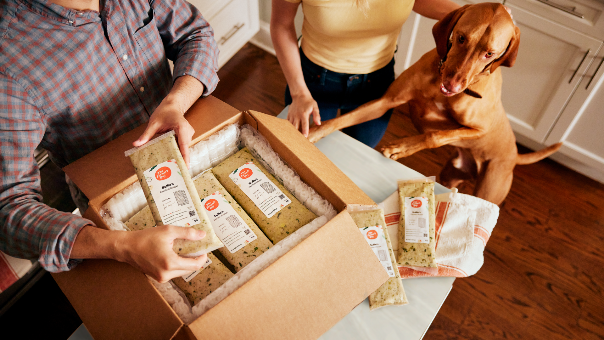 family and dog opening box of dog food