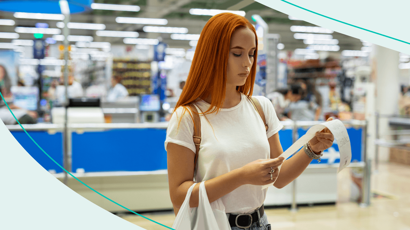woman in store looking with concern at receipt