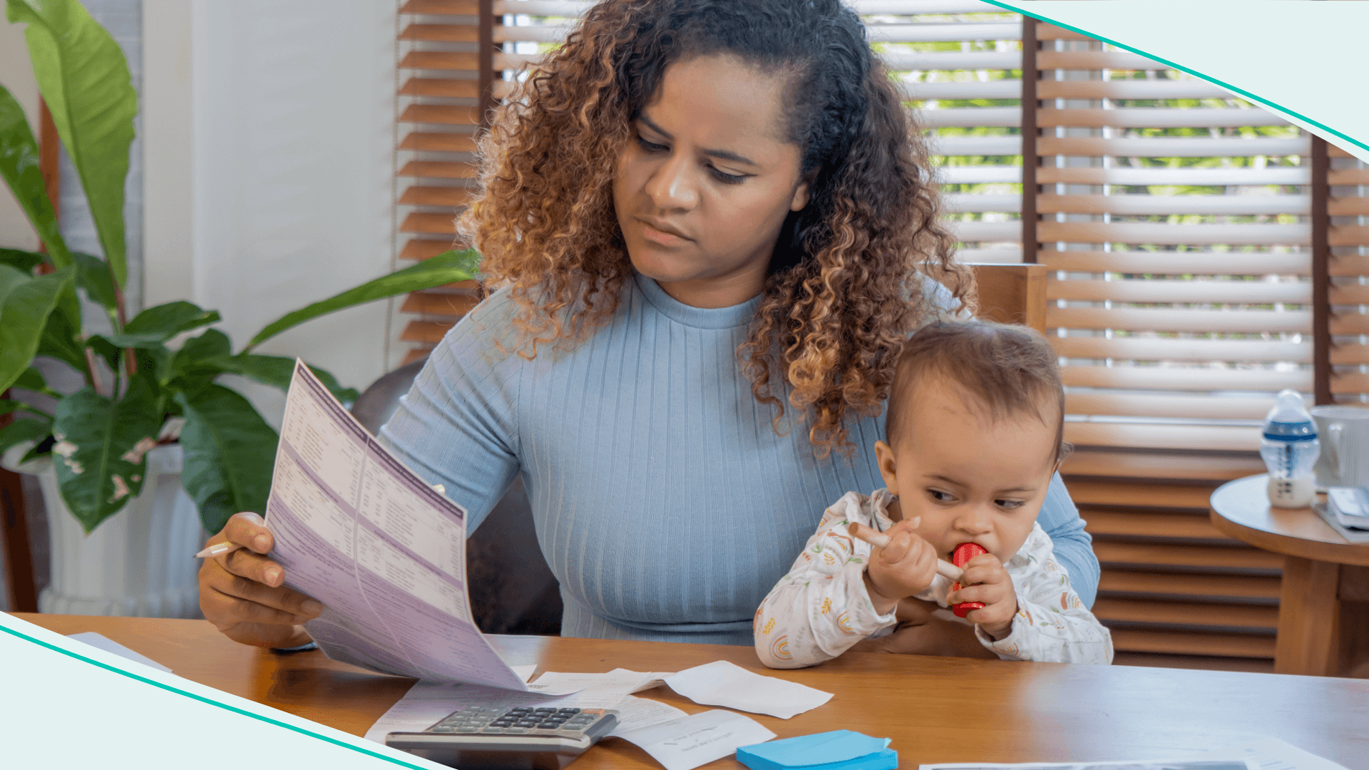 Mother managing the monthly family budget while taking care of her baby daughter