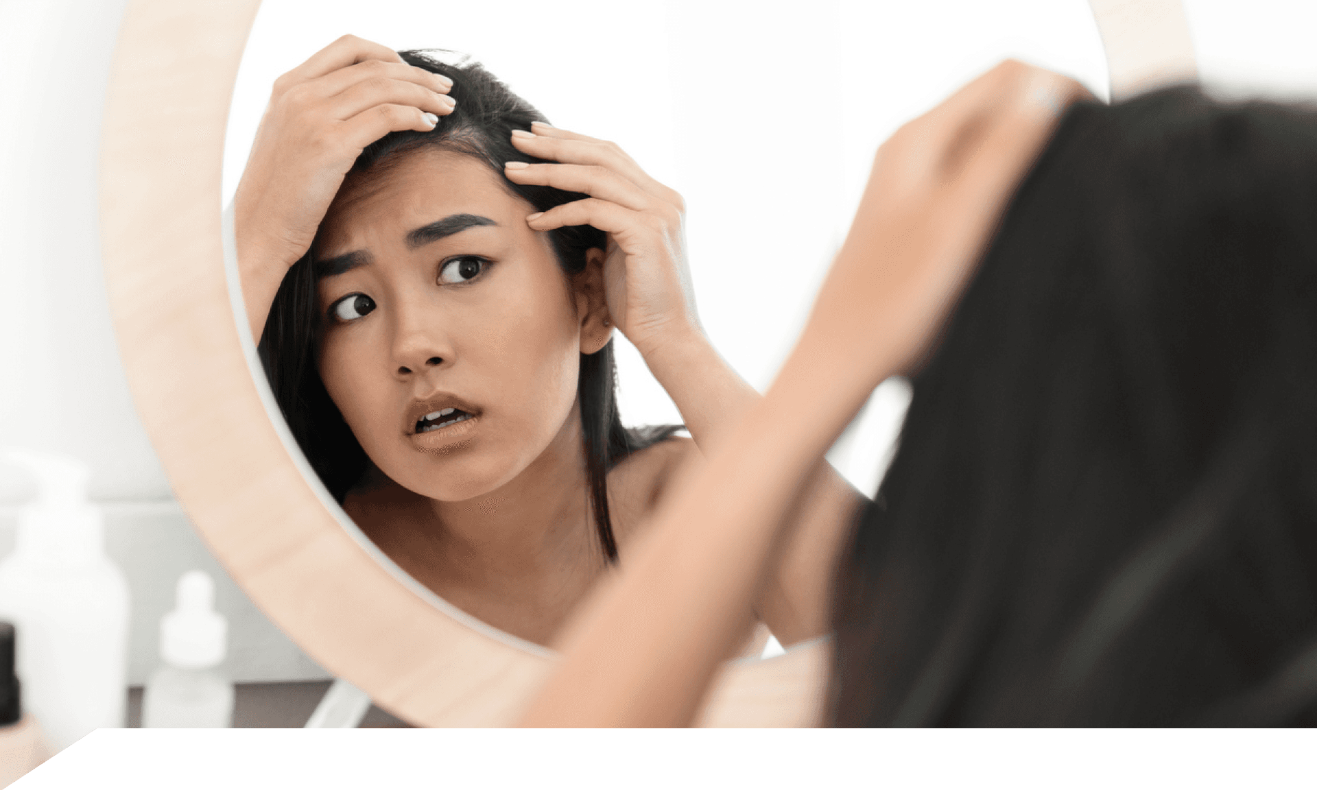Woman looking at scalp in mirror