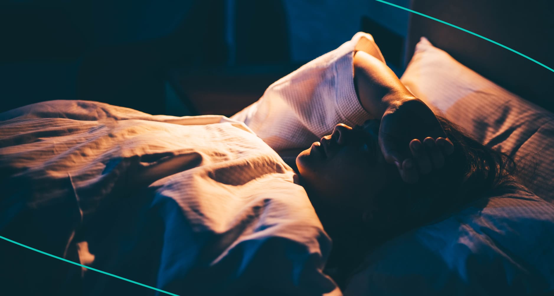 Woman lying in bed with her hand on her forehead.