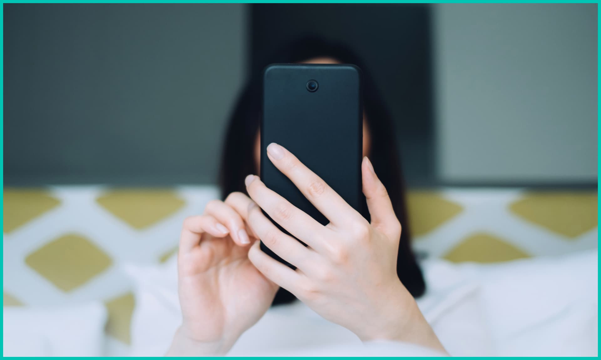 Portrait of woman using mobile phone while lying on bed
