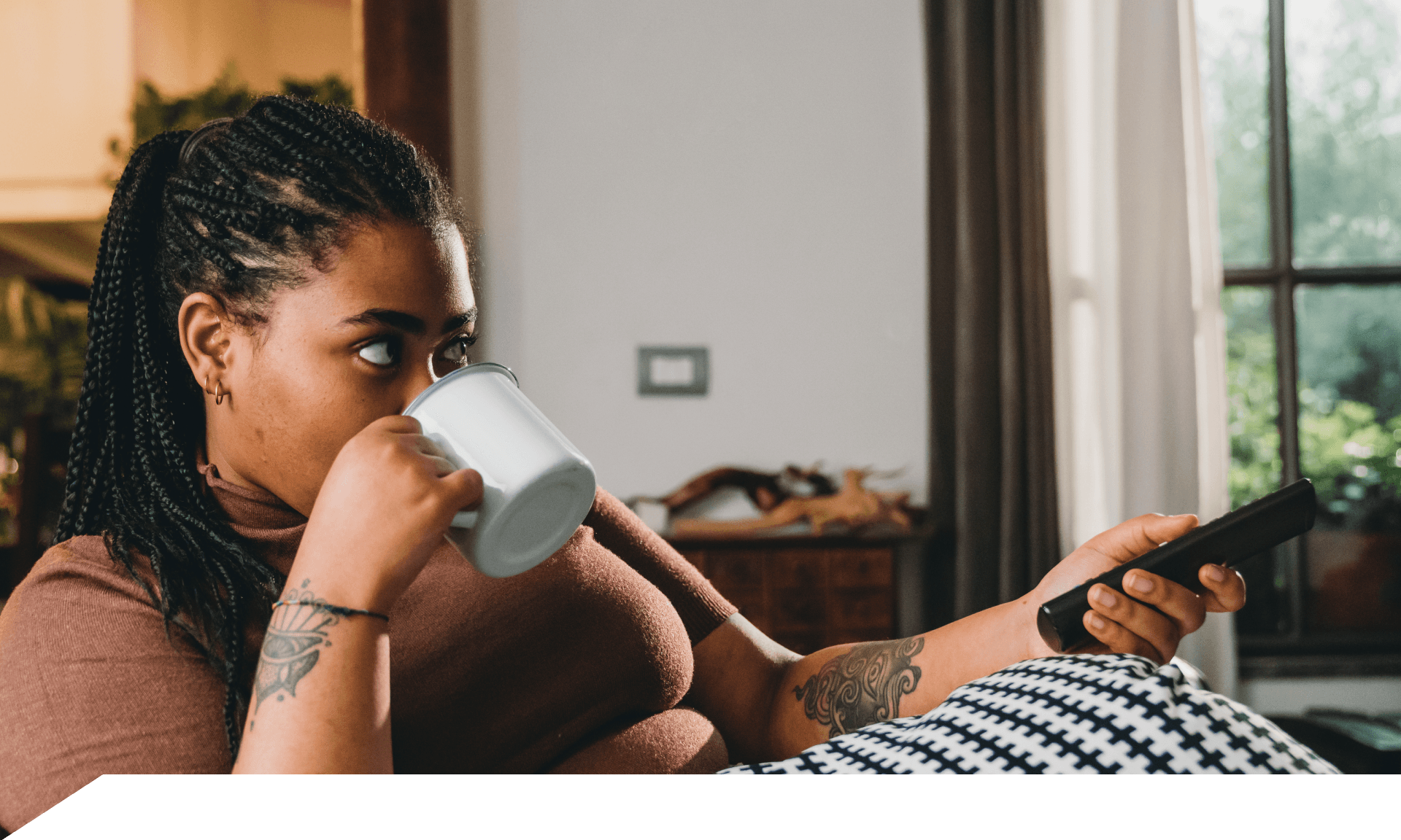 A woman laying on her couch watching TV