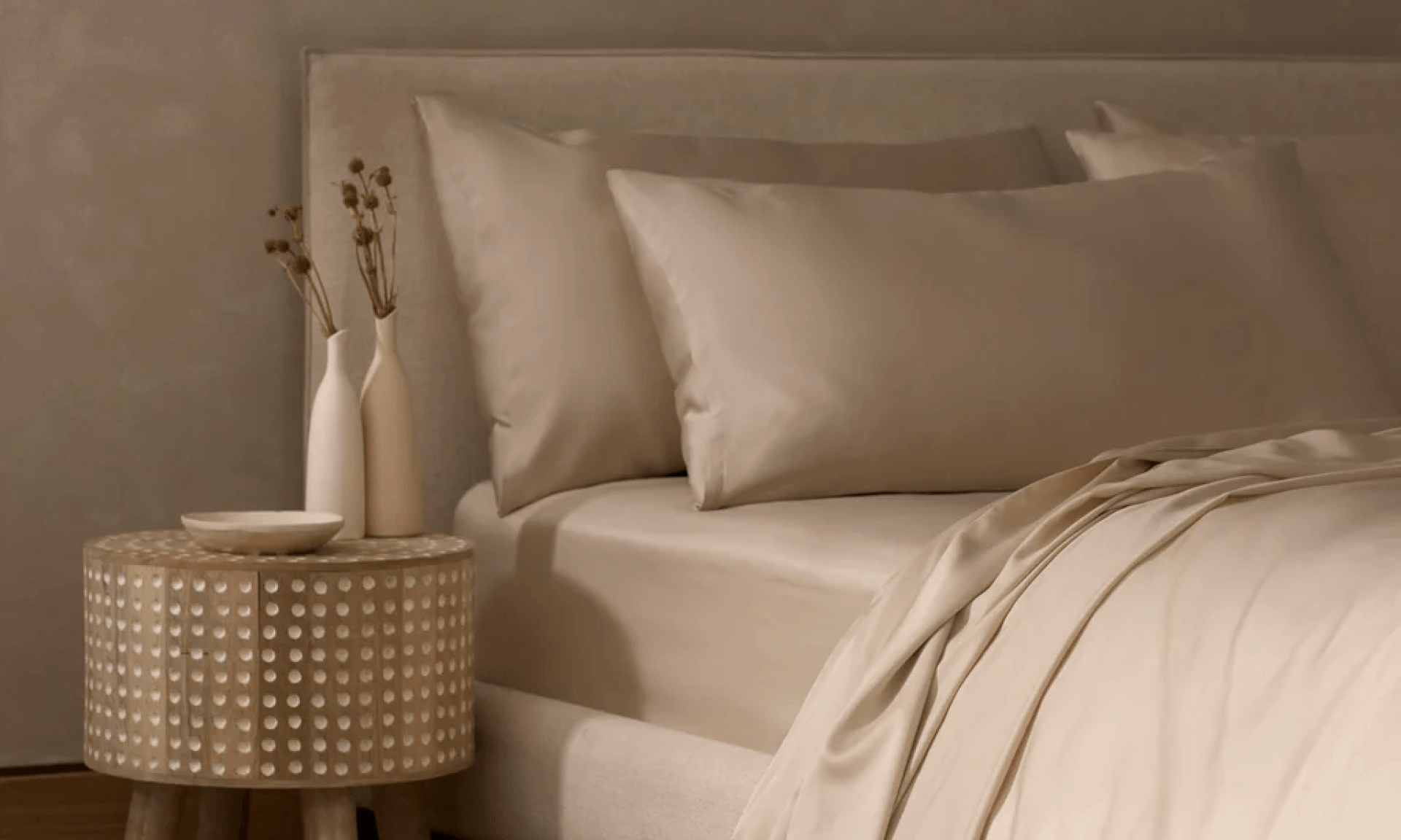 Bedroom featuring beige sheets and a wooden nightstand