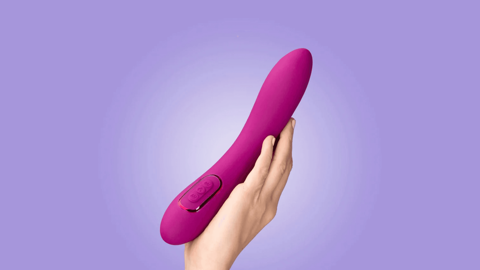 Hand holding pink vibrator on purple background