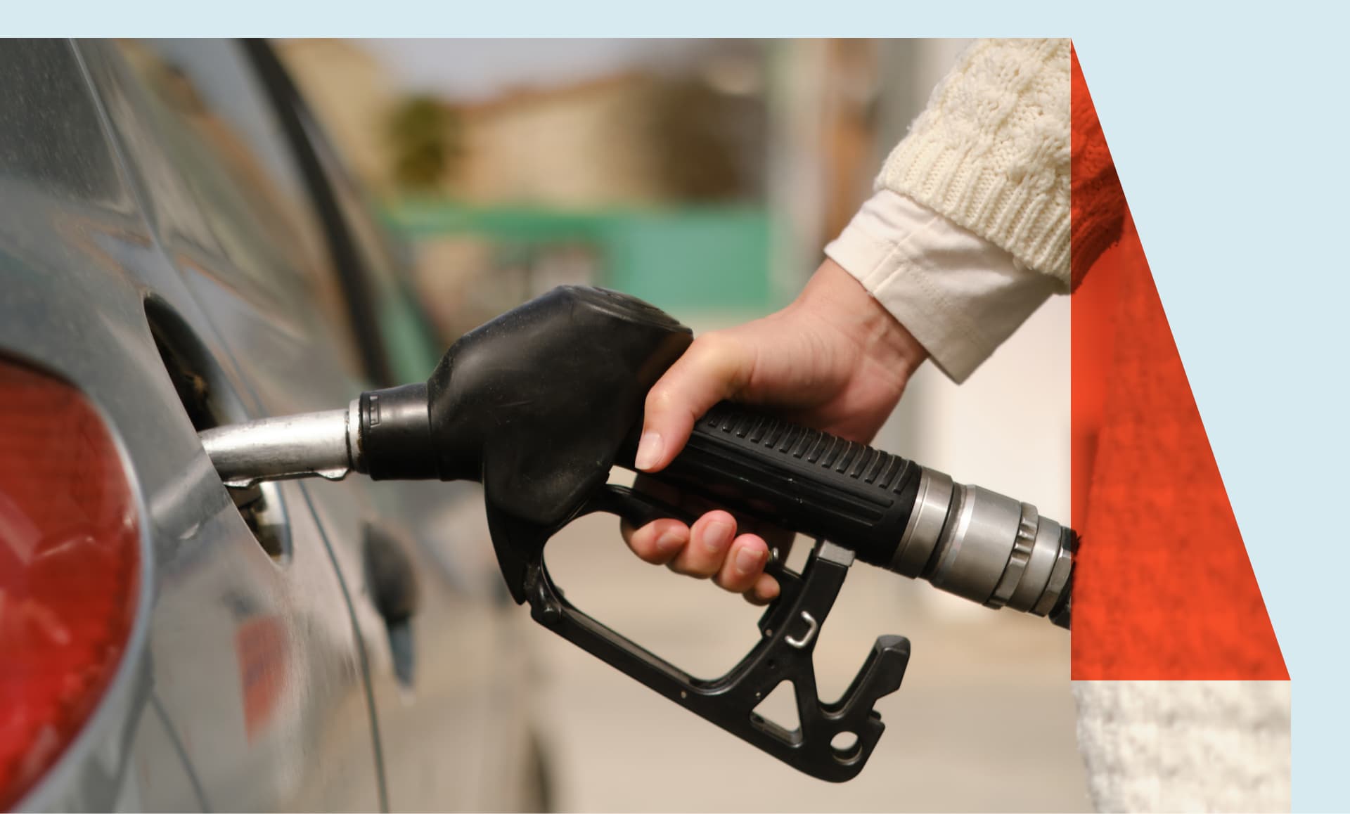 A woman fills up her gas tank at a gas station.