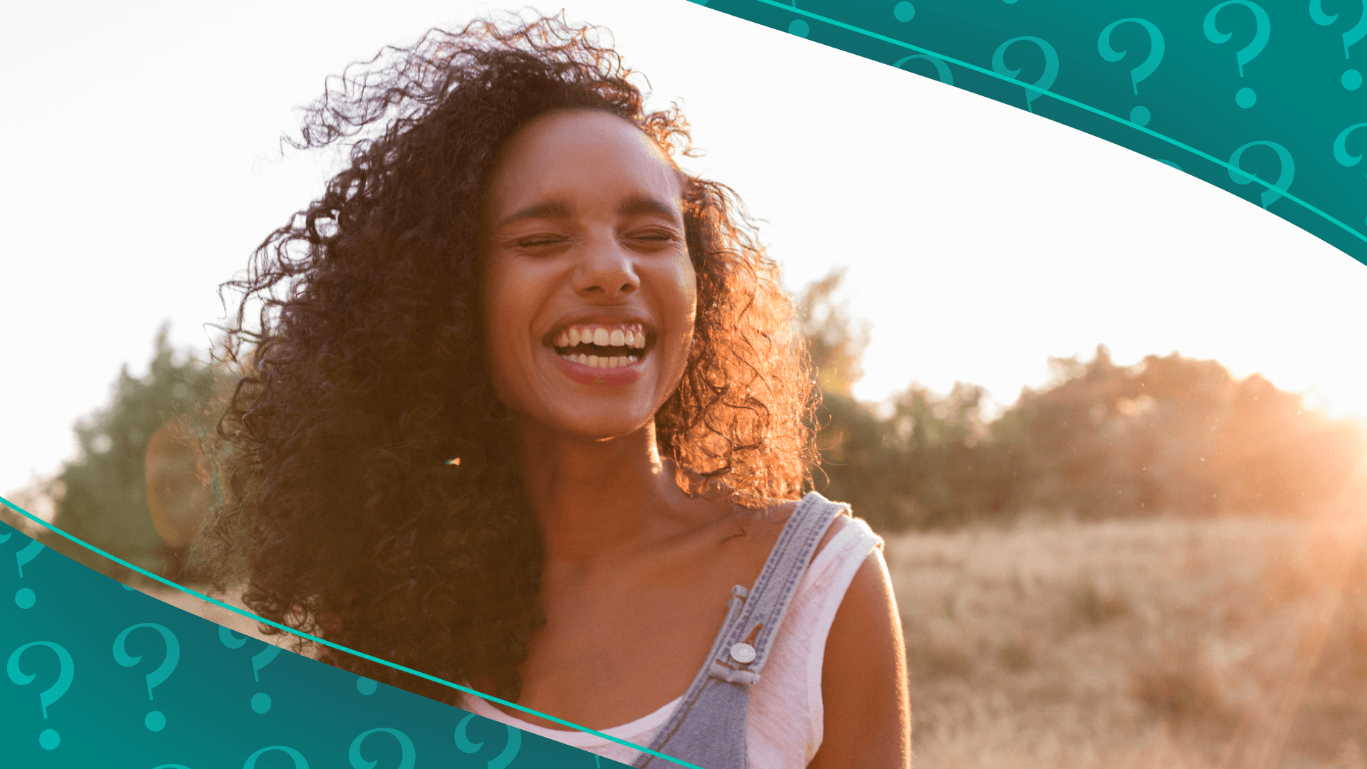 Woman with curly hair at sunset smiling