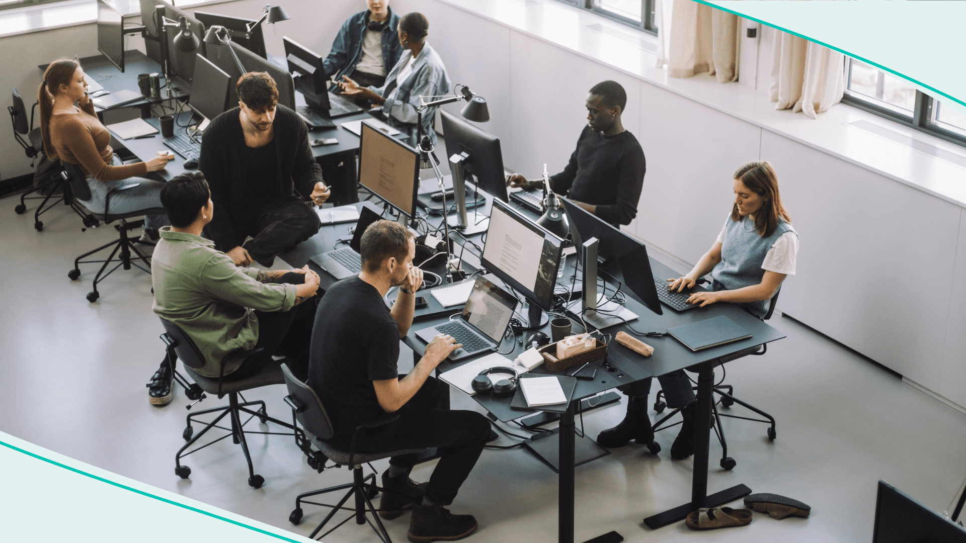 High angle view of male and female programmers working on computers at desk in office