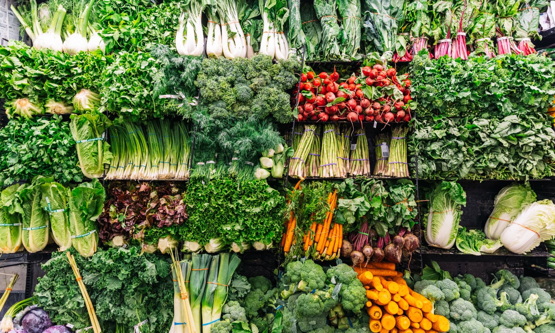 Fresh greens and vegetables on a display in a supermarket
