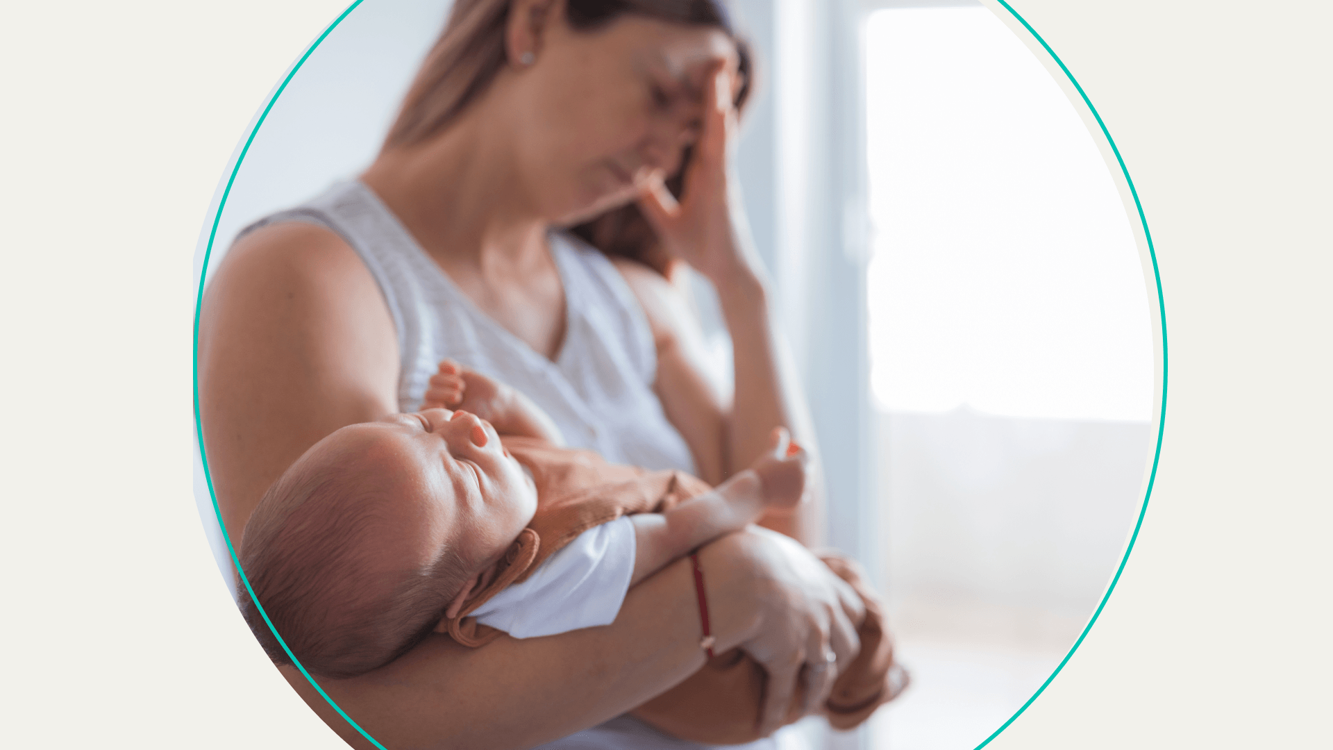 Woman holds baby while massaging forehead