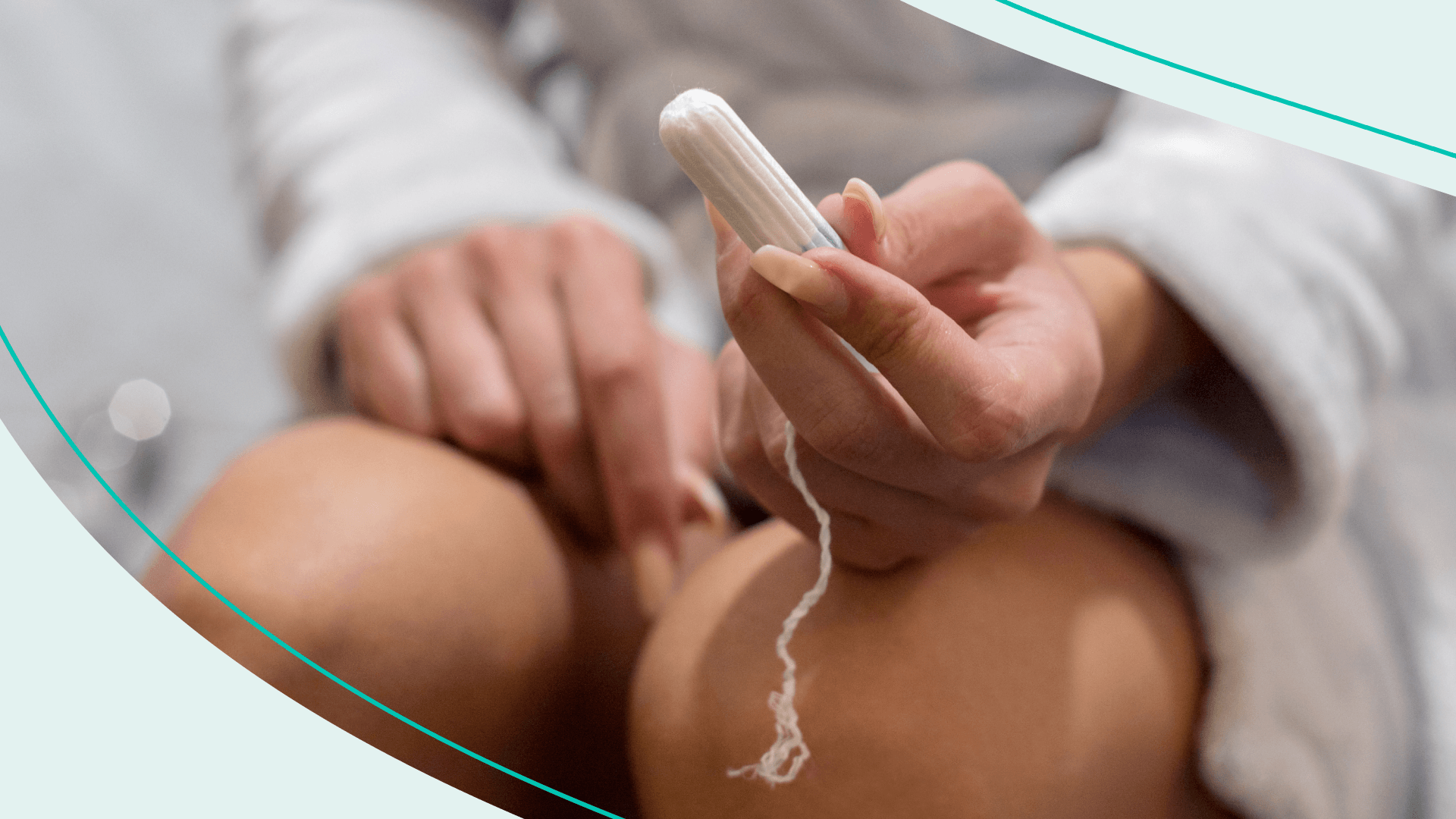 A person sitting and holding a tampon