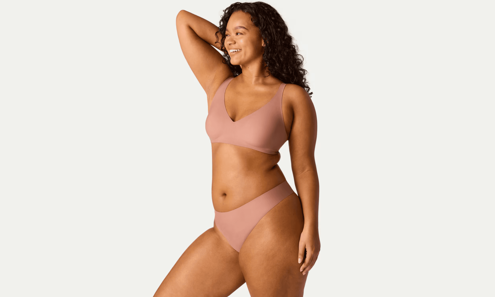 Woman standing in pale pink bra and underwear