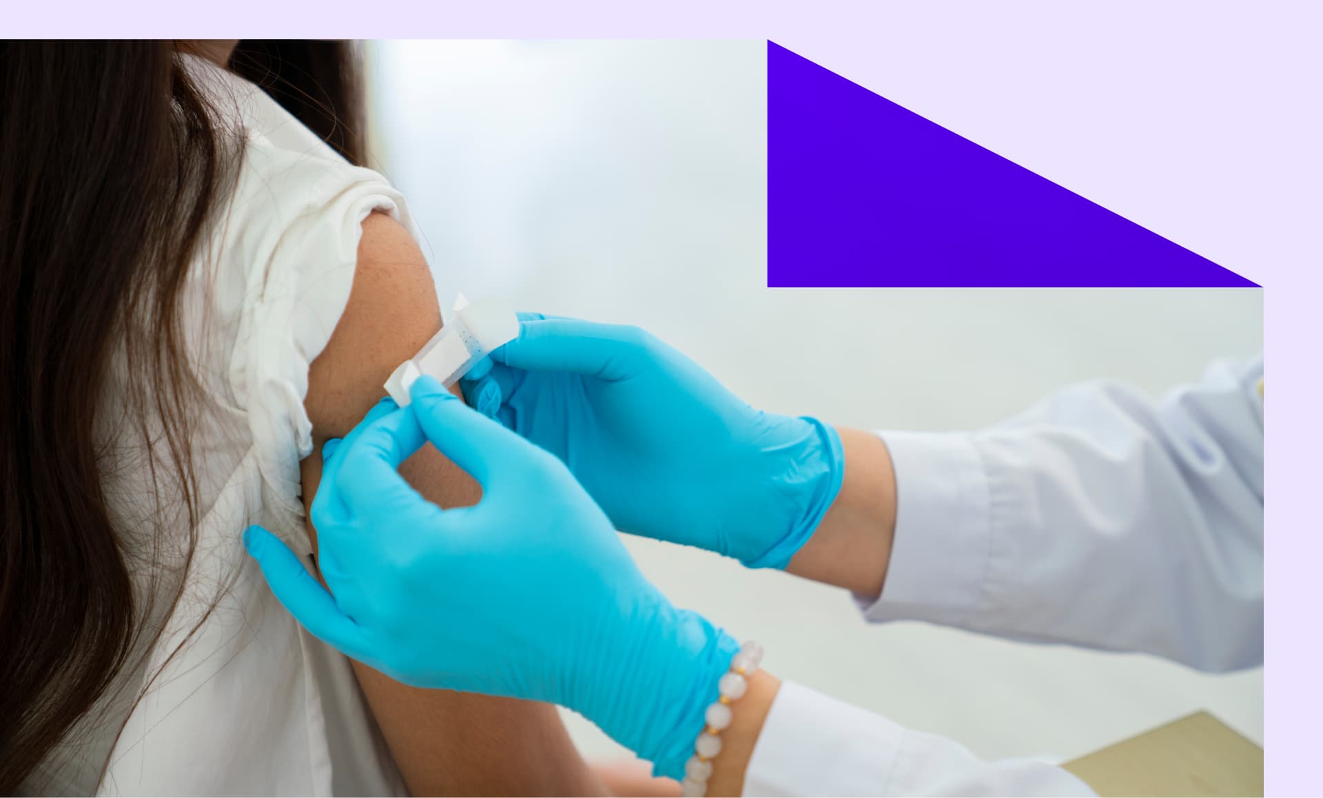 Doctor applies bandage to preteen girl's arm following an immunization.