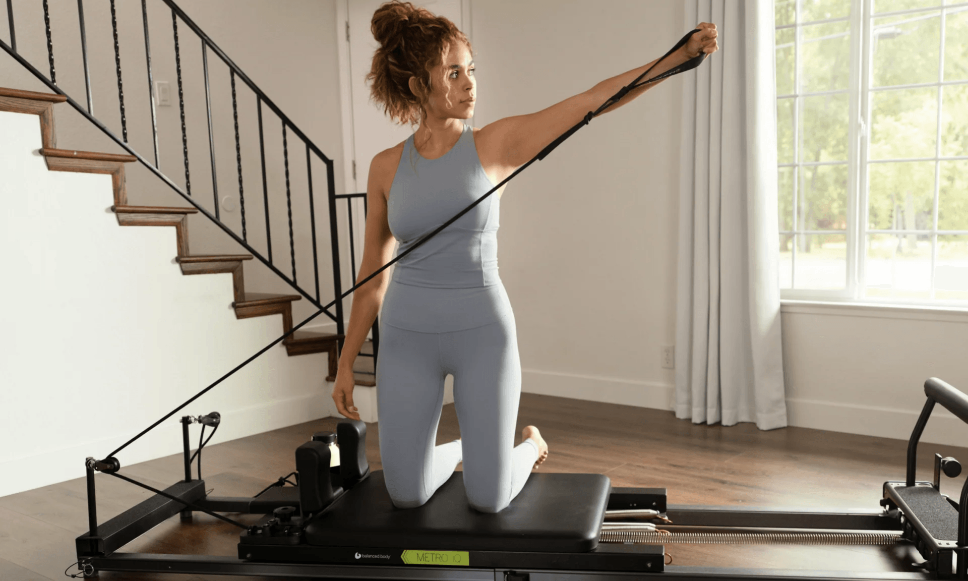Woman using pilates reformer machine