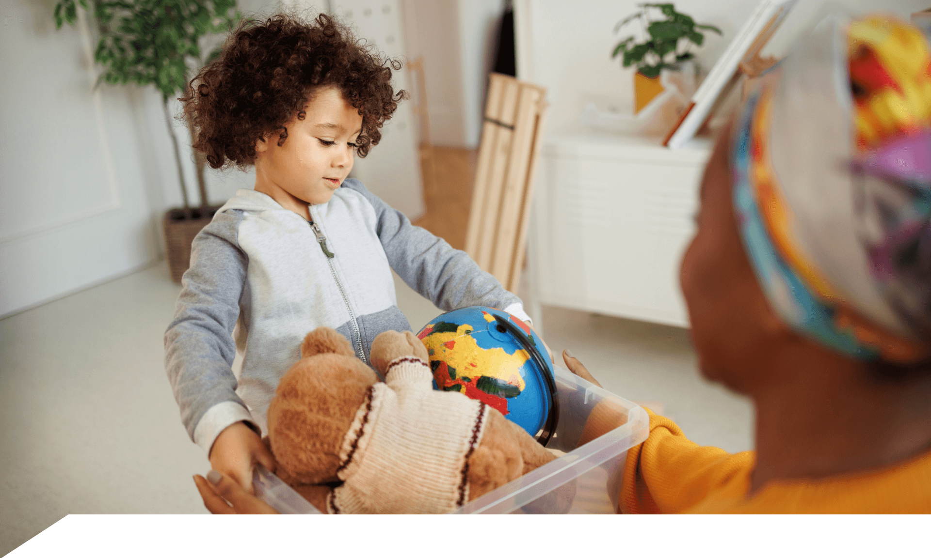 Child holding toy bin