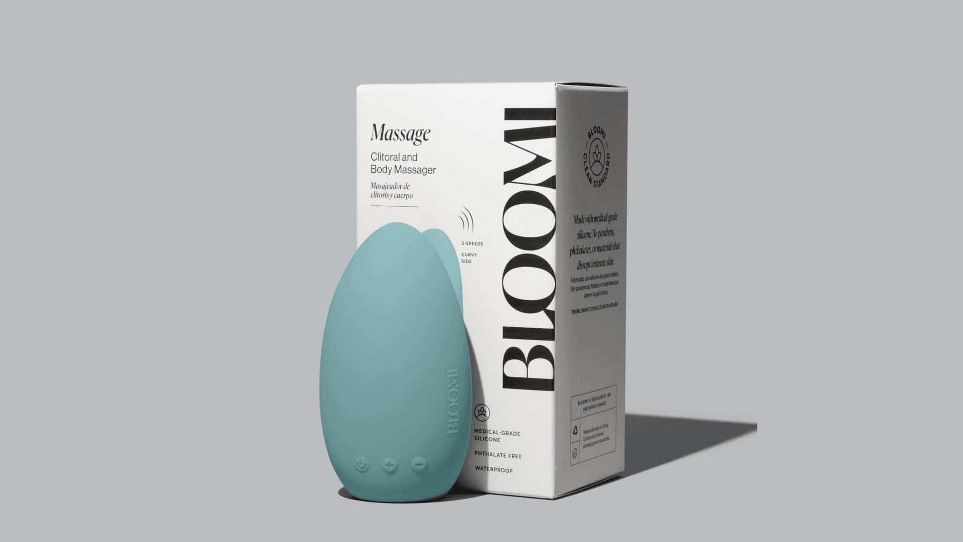 Light teal pebble shaped vibrator leaning against white product box