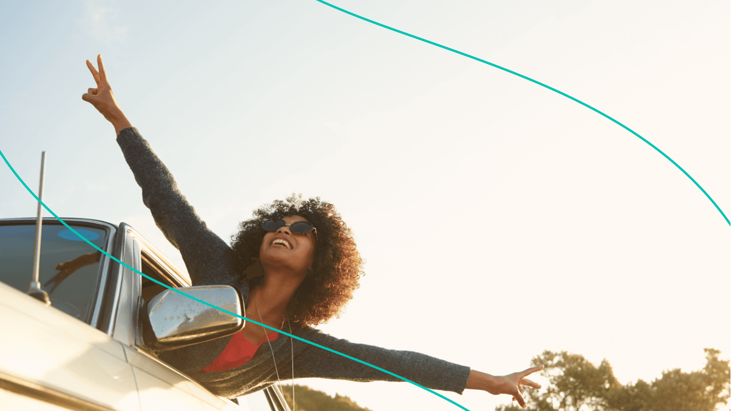 woman leaning out car window holding up peace signs