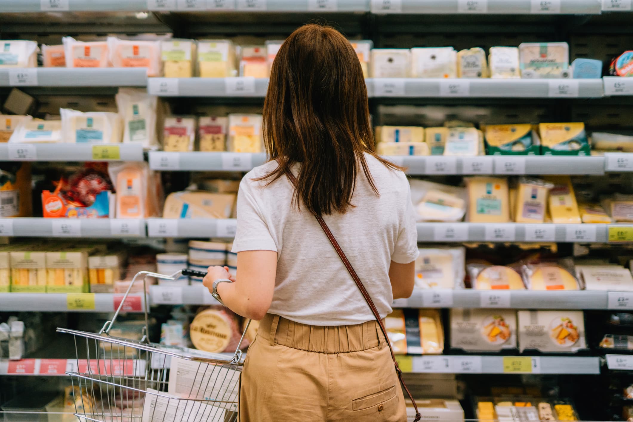 A woman stands and looks at a grocery aisle