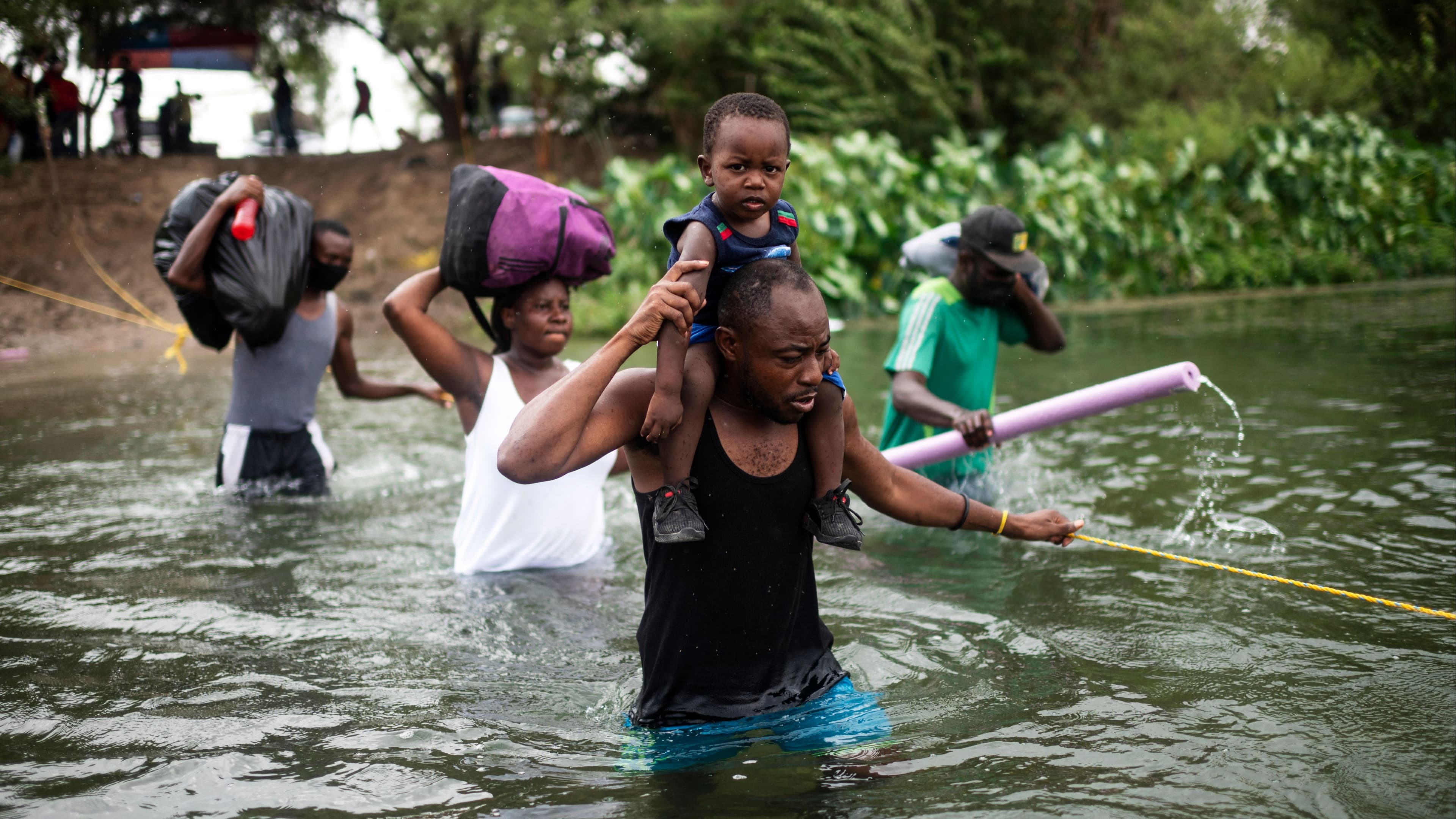 Haitian migrants cross the Rio Grande river at US-Mexico border to get food and water in Mexico on September 21, 2021.