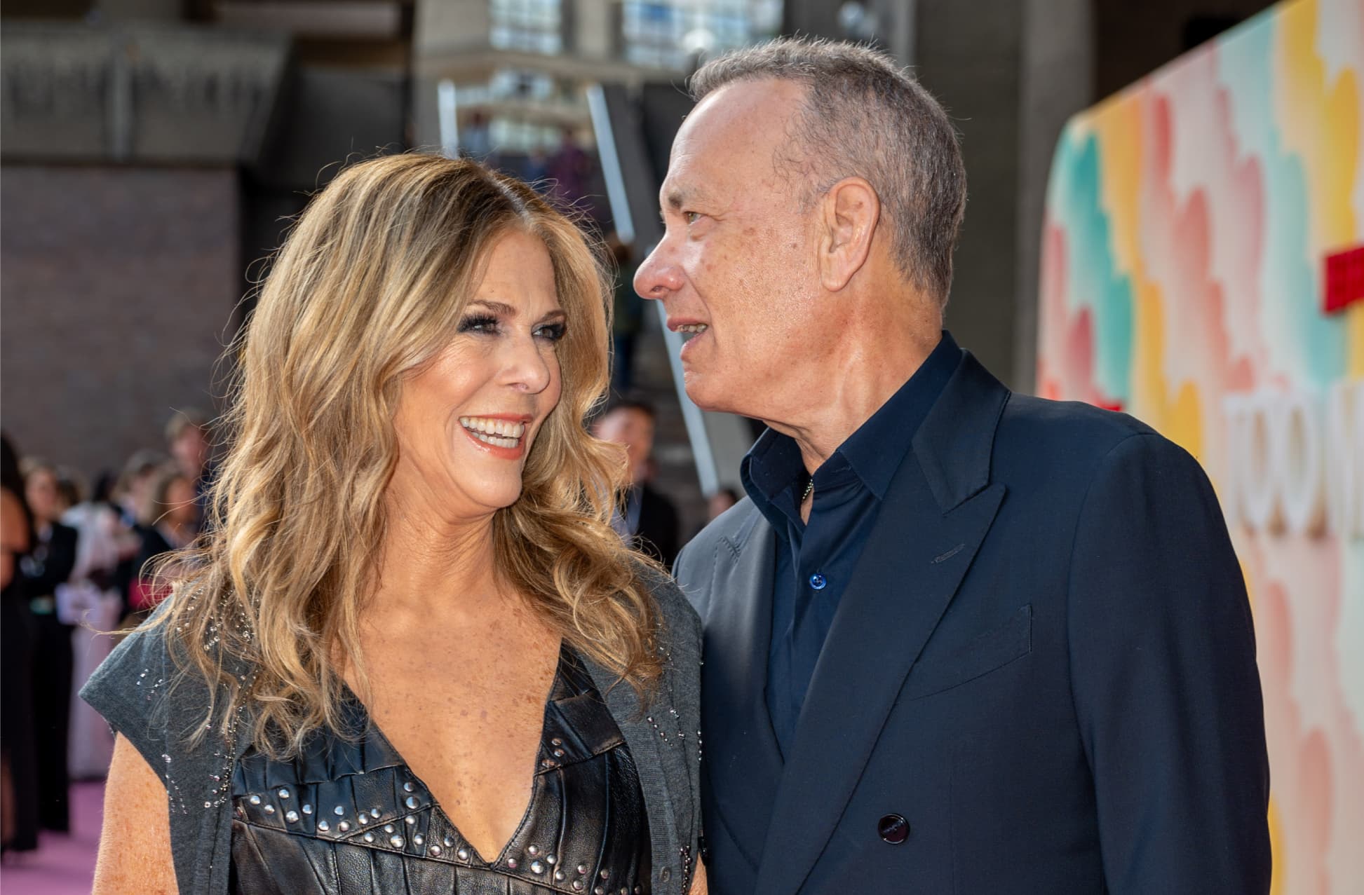 Tom Hanks whispering to Rita Wilson
