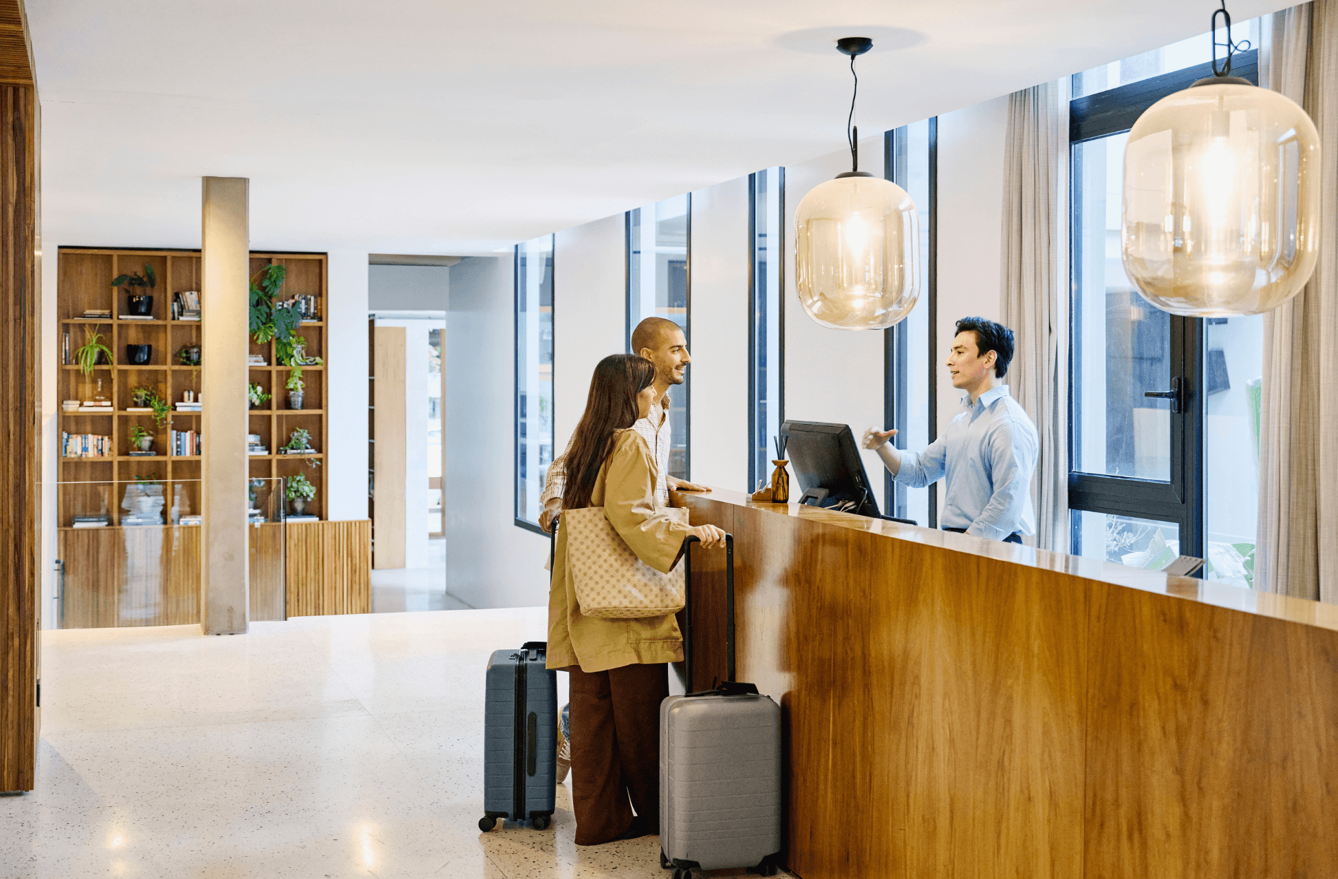 Tourist couple checking in at hotel reception desk