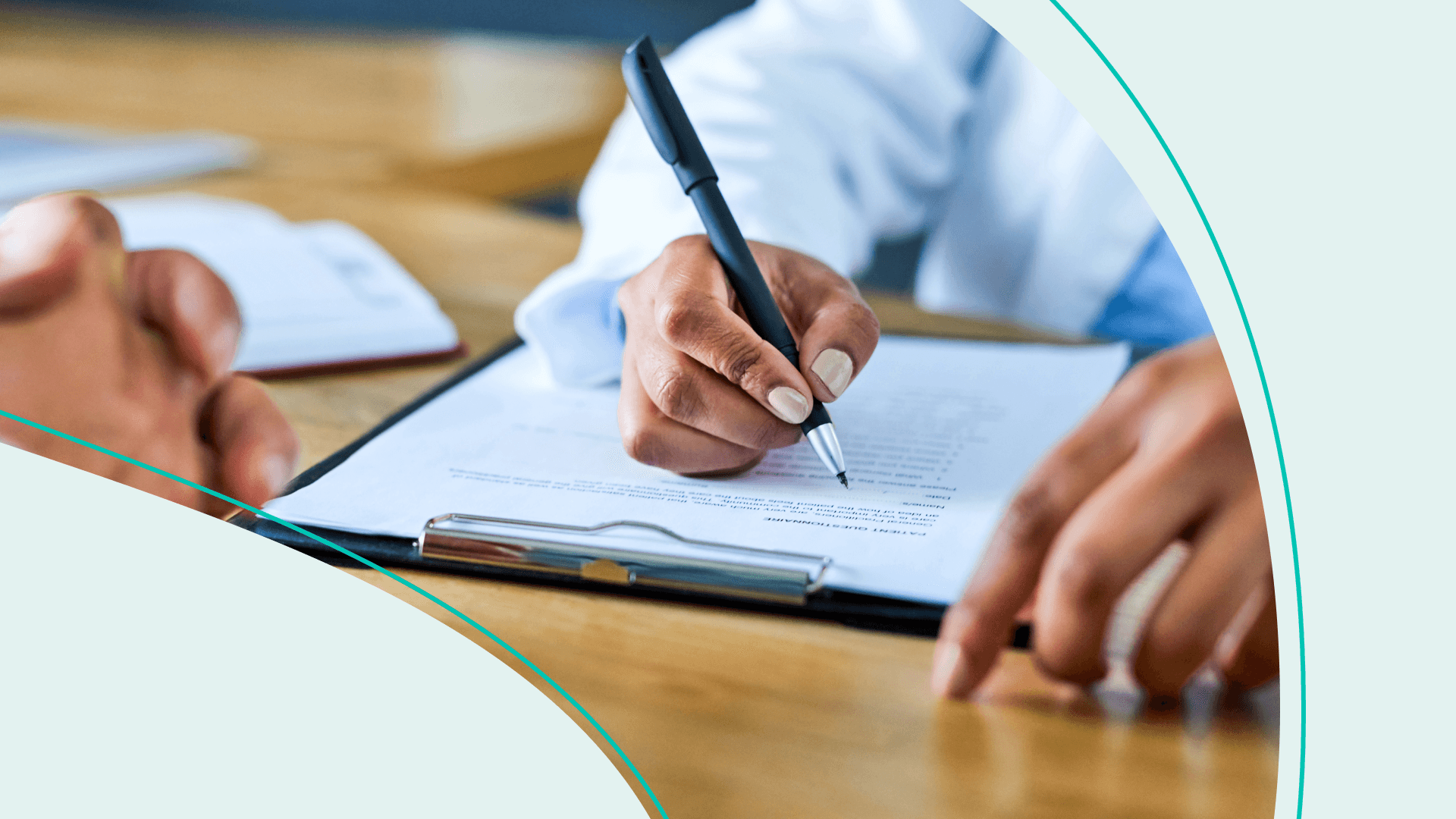 A doctor writing on a clipboard across from a patient