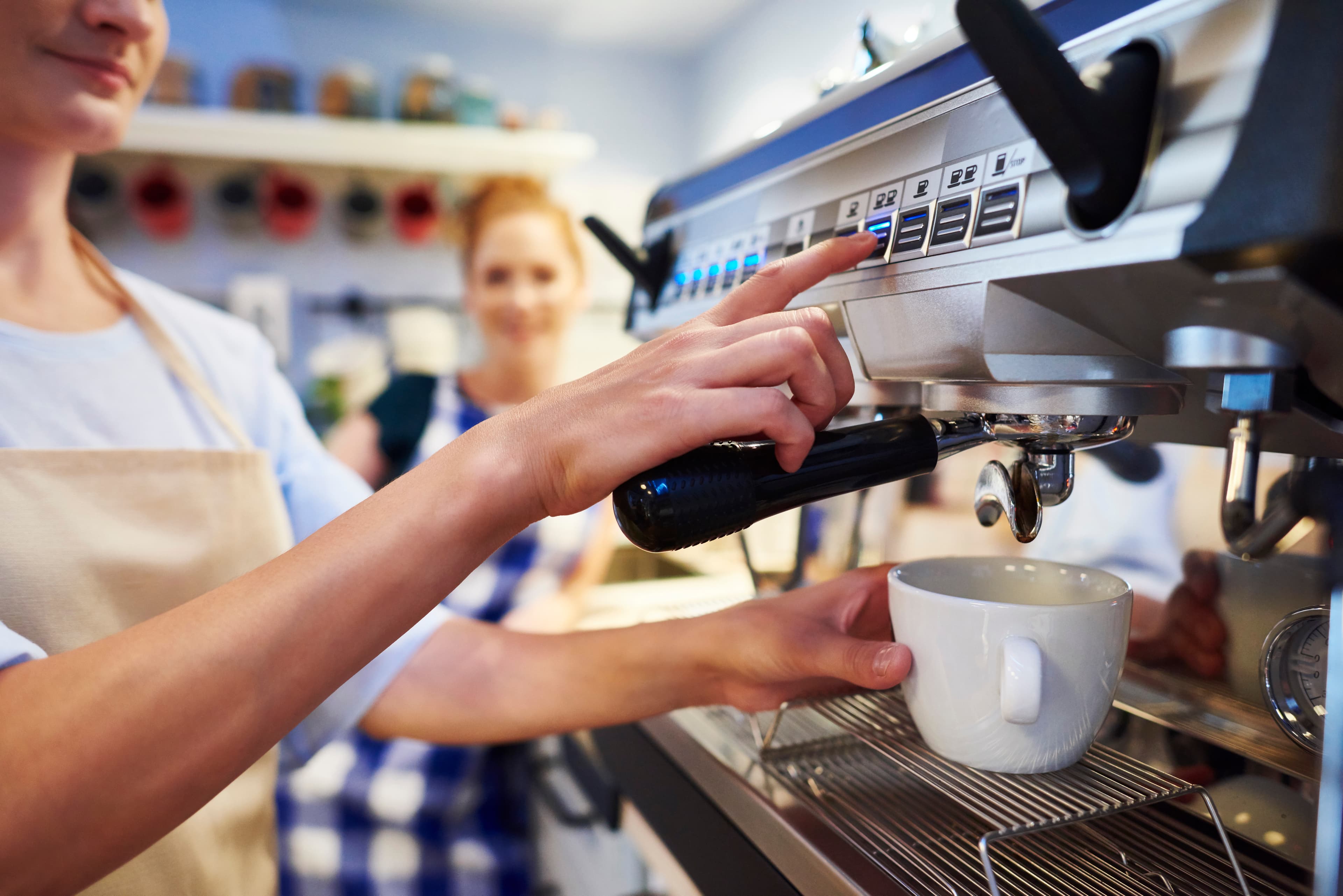 A female barista makes coffee at a cafe