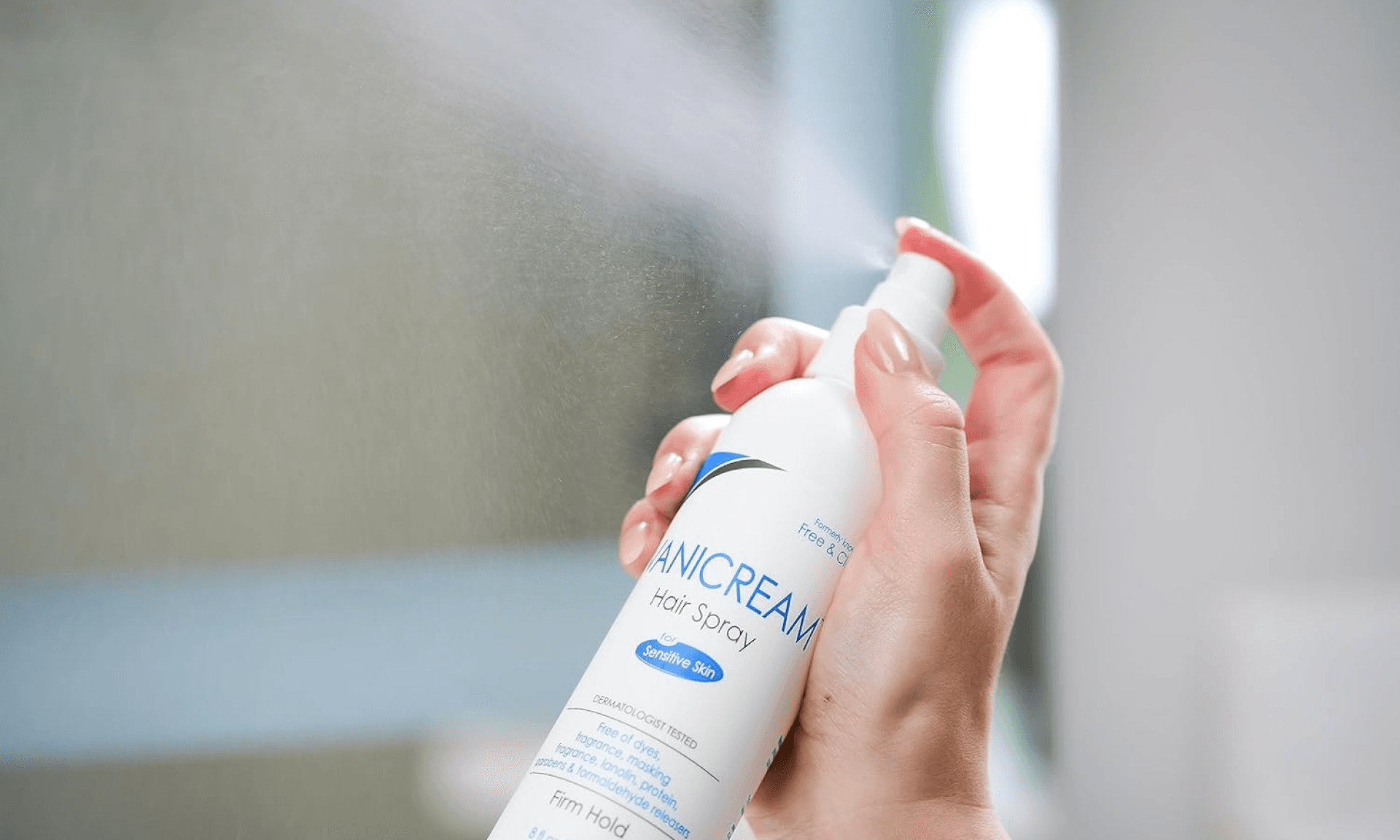 Hand spraying Vanicream hair spray into air