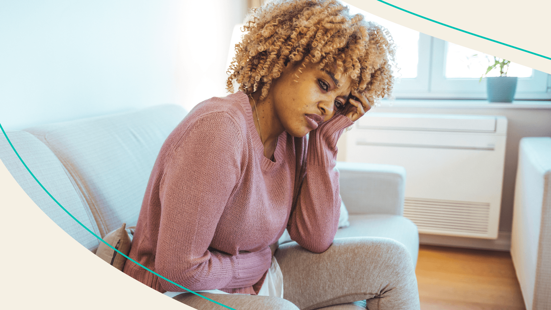 Woman sitting on a couch with her arm across her stomach