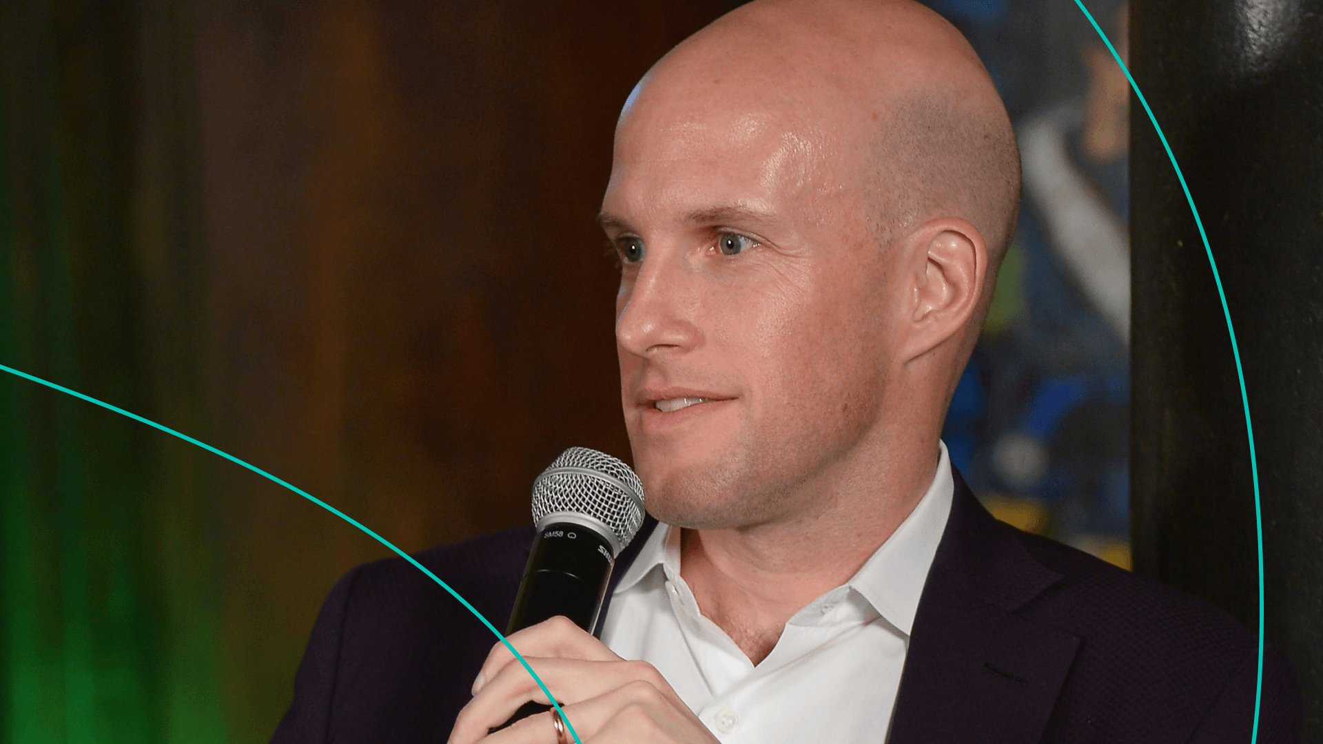 A photo of sports journalist Grant Wahl holding a microphone