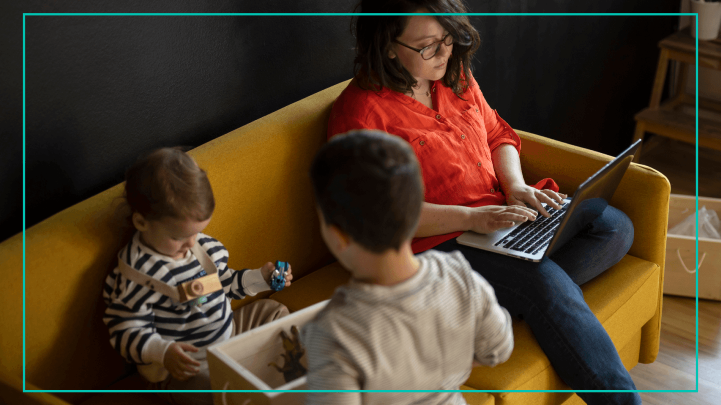 woman on couch with her two kids on laptop stock image