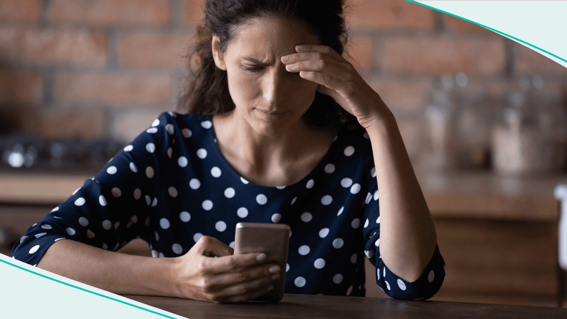 Woman looking at phone with hand on face