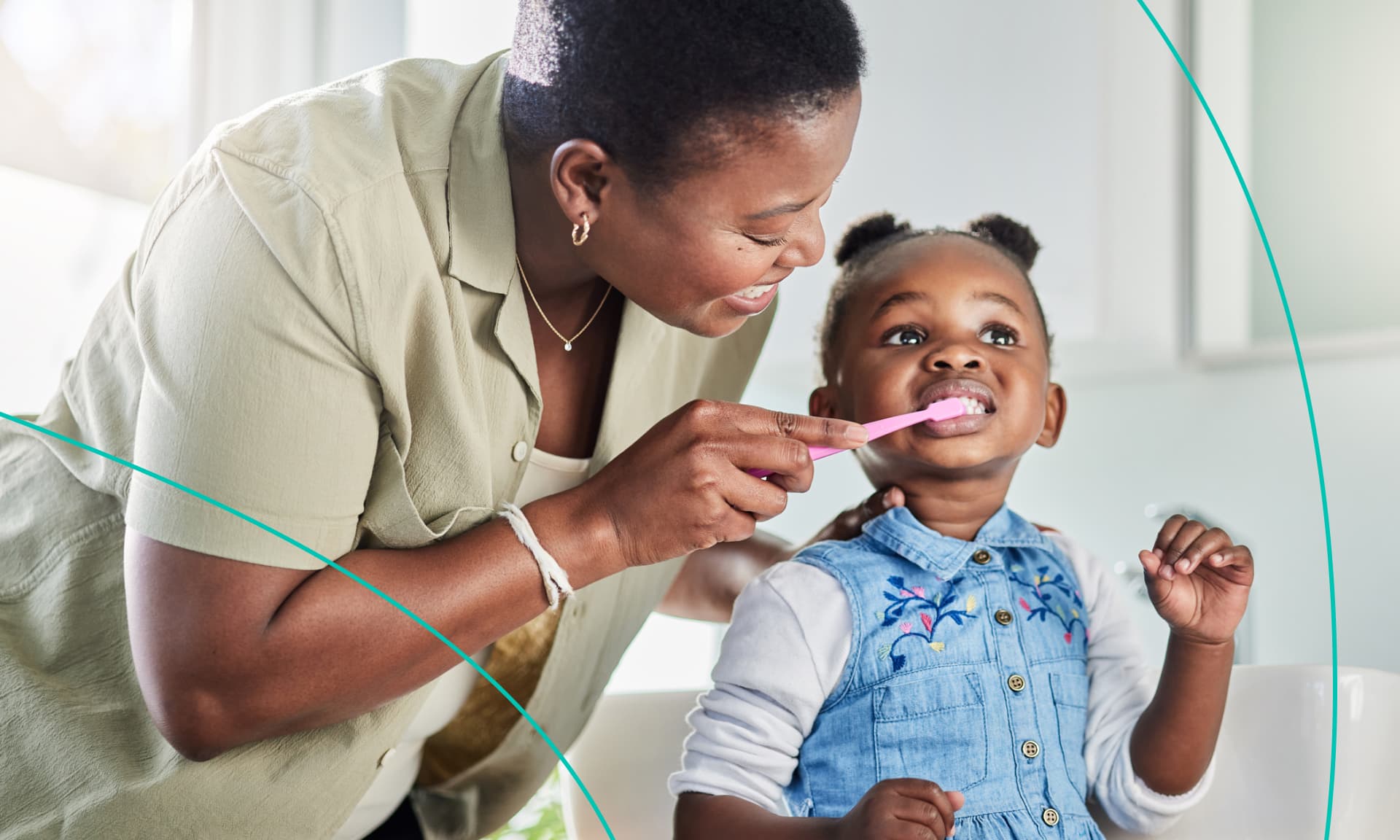 mom helping brush her daughter's teeth