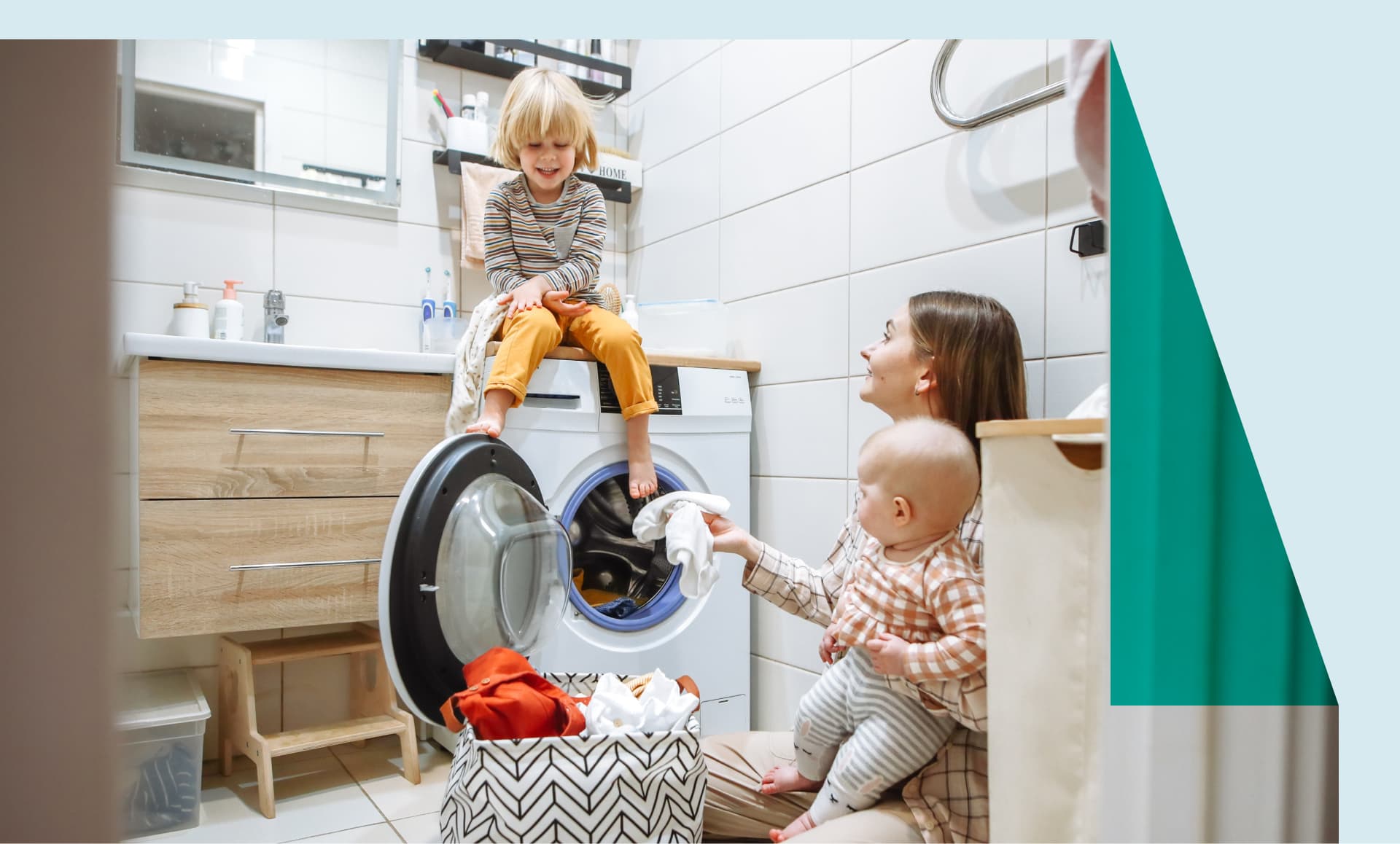 Mom doing laundry with two young children