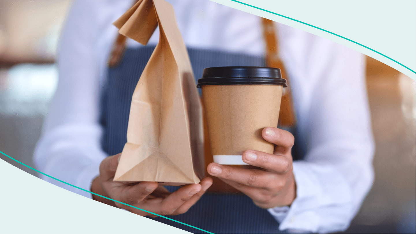 barista serving coffee and pastry bag