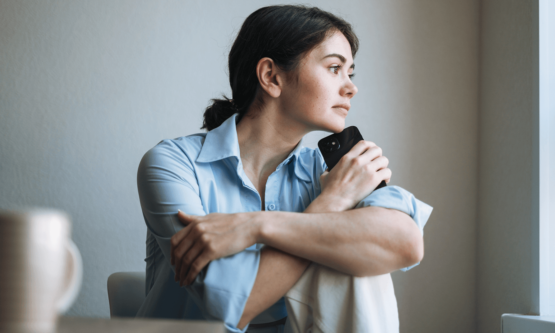 Woman thinking with phone