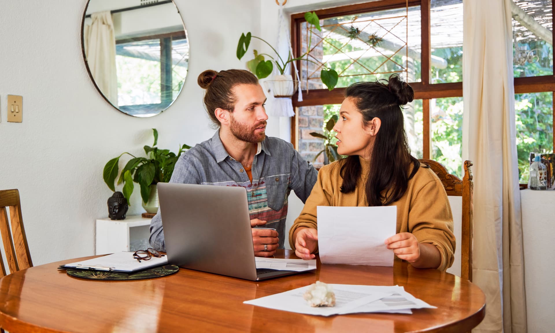 Woman and man sitting at a table arguing about expenses.