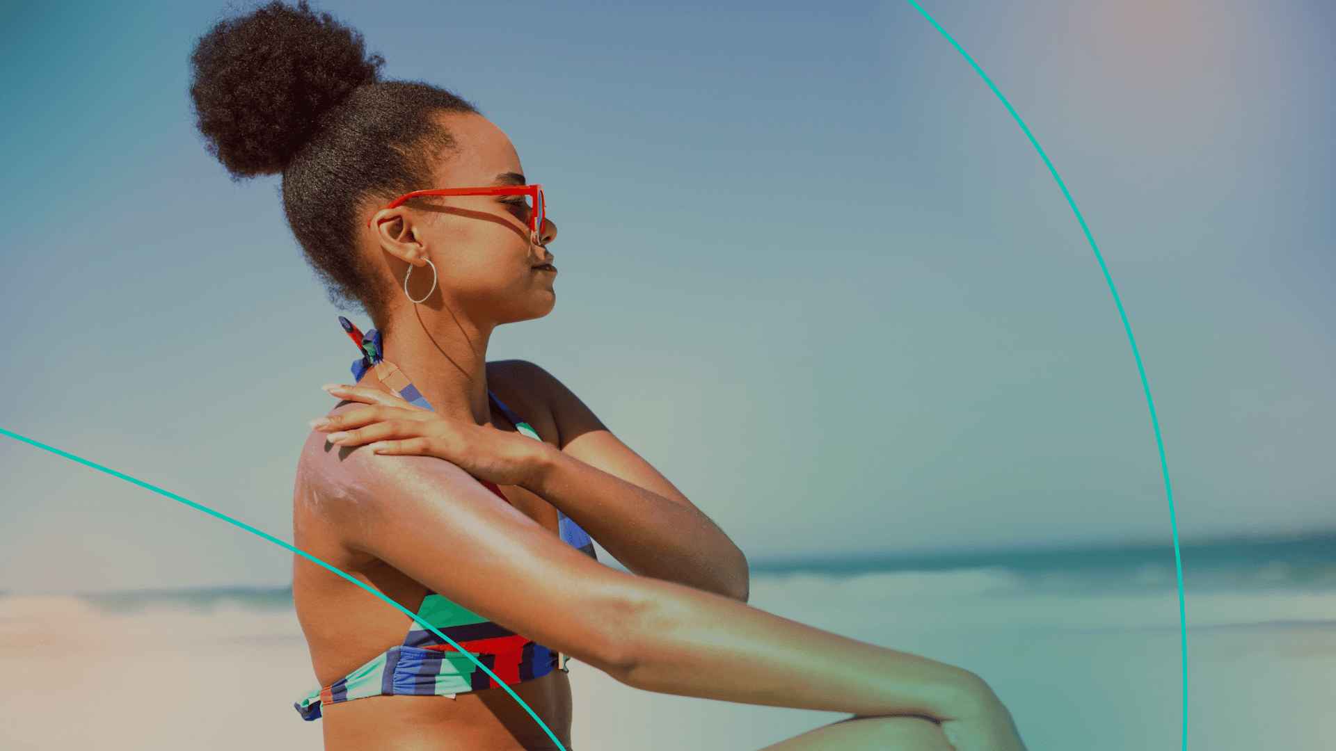 woman putting on sunscreen on the beach