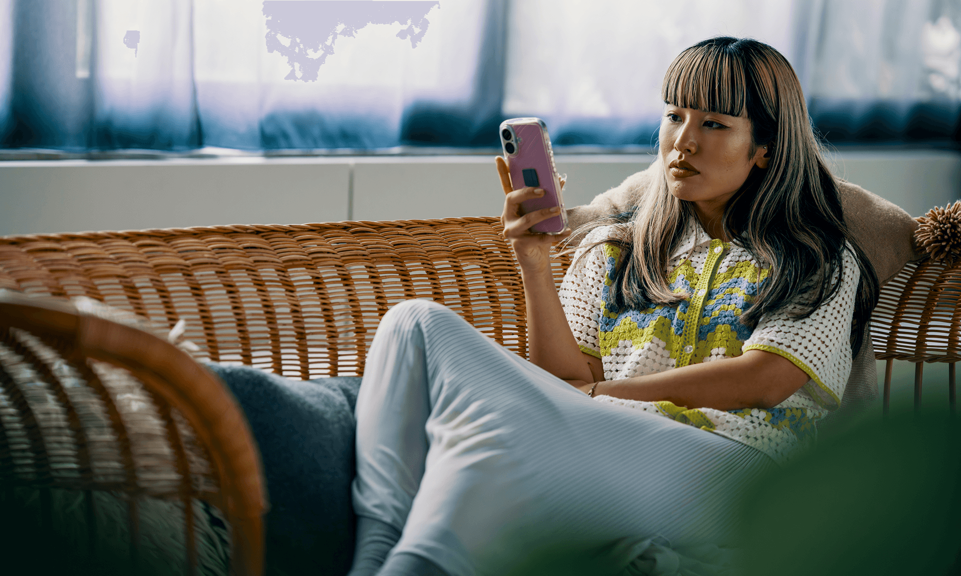 woman sitting on couch with phone