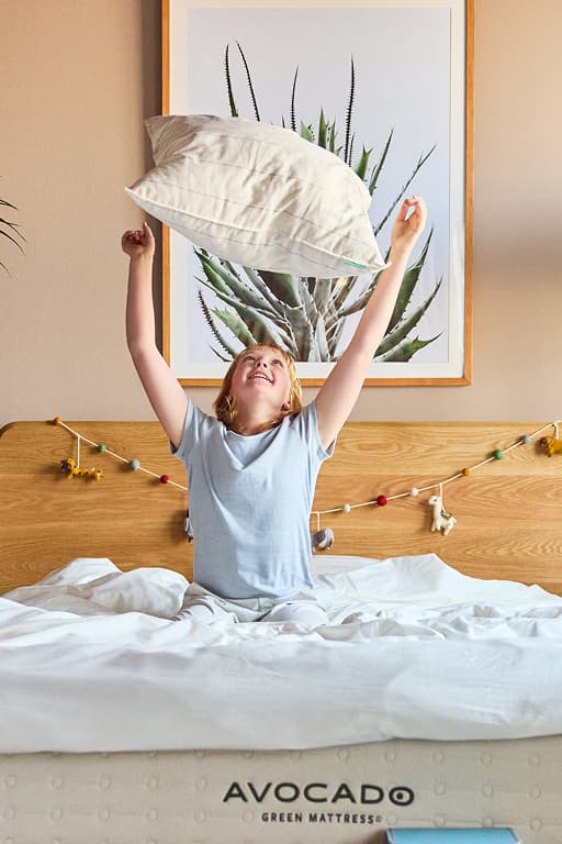 child throwing a pillow