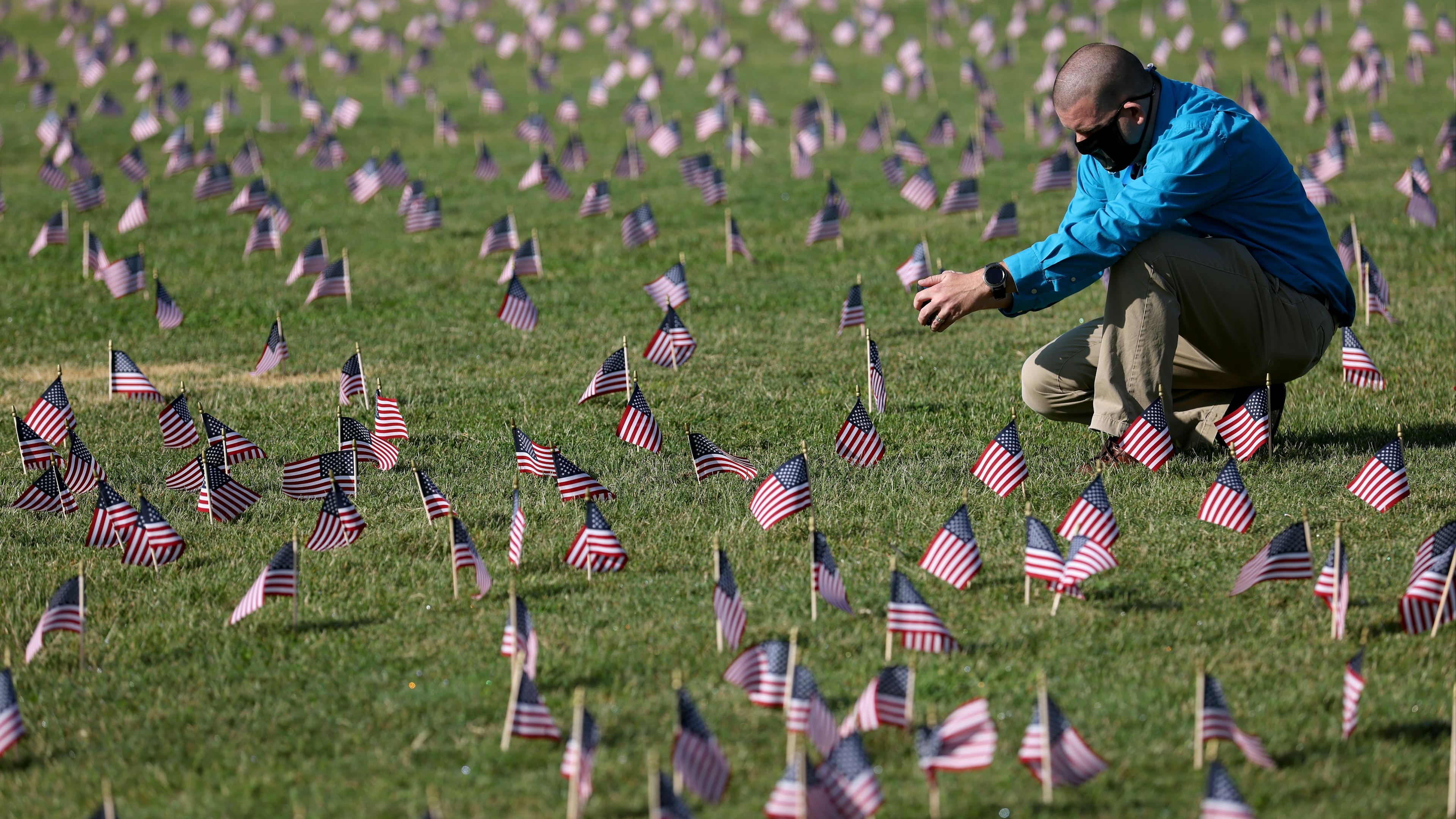 Chris Duncan, whose 75 year old mother Constance died from COVID on her birthday, photographs a COVID Memorial Project installation of 20,000 American flags on the National Mall as the United States crosses the 200,000 lives lost in the COVID-19 pandemic