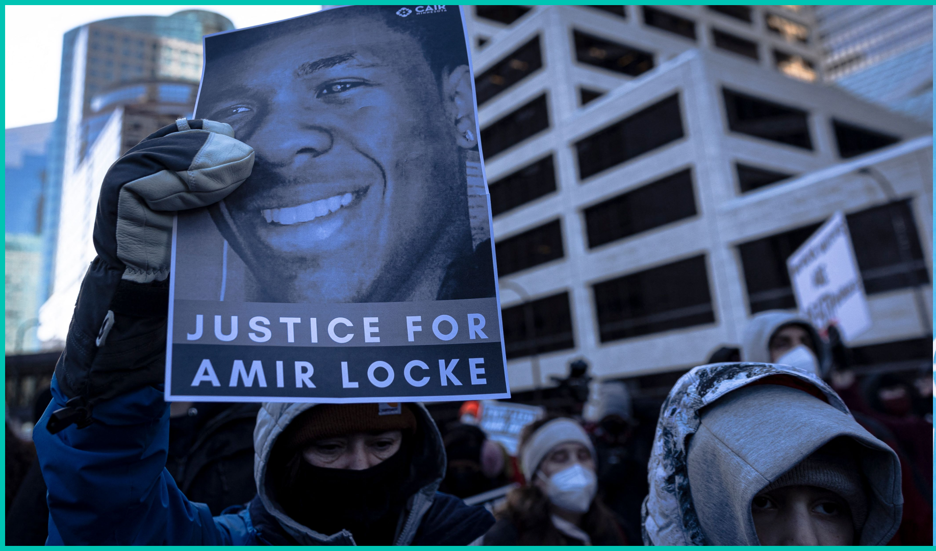 A demonstrator holds a photo of Amir Locke during a rally in protest of his killing