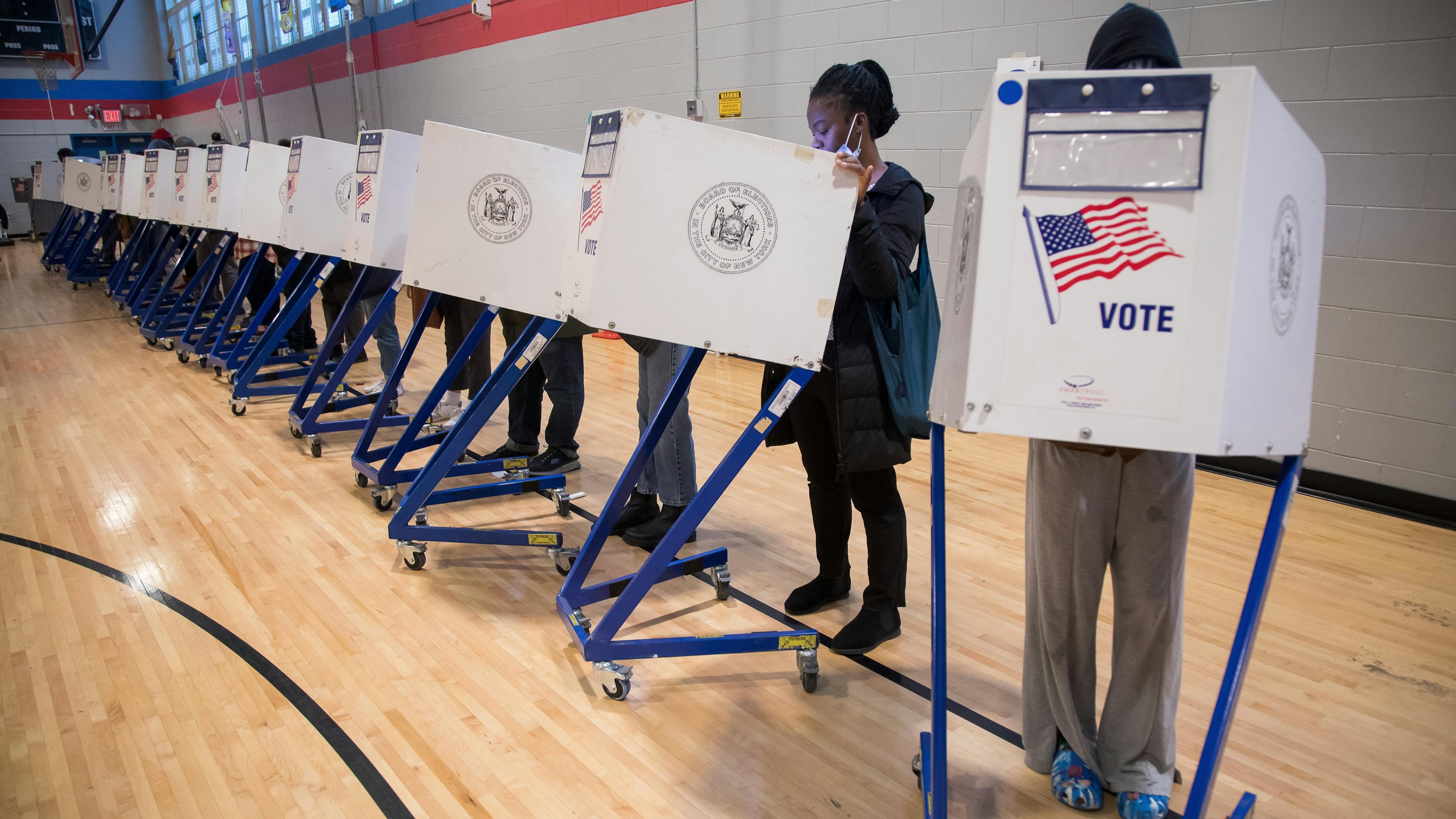 People filling out ballots in a gym