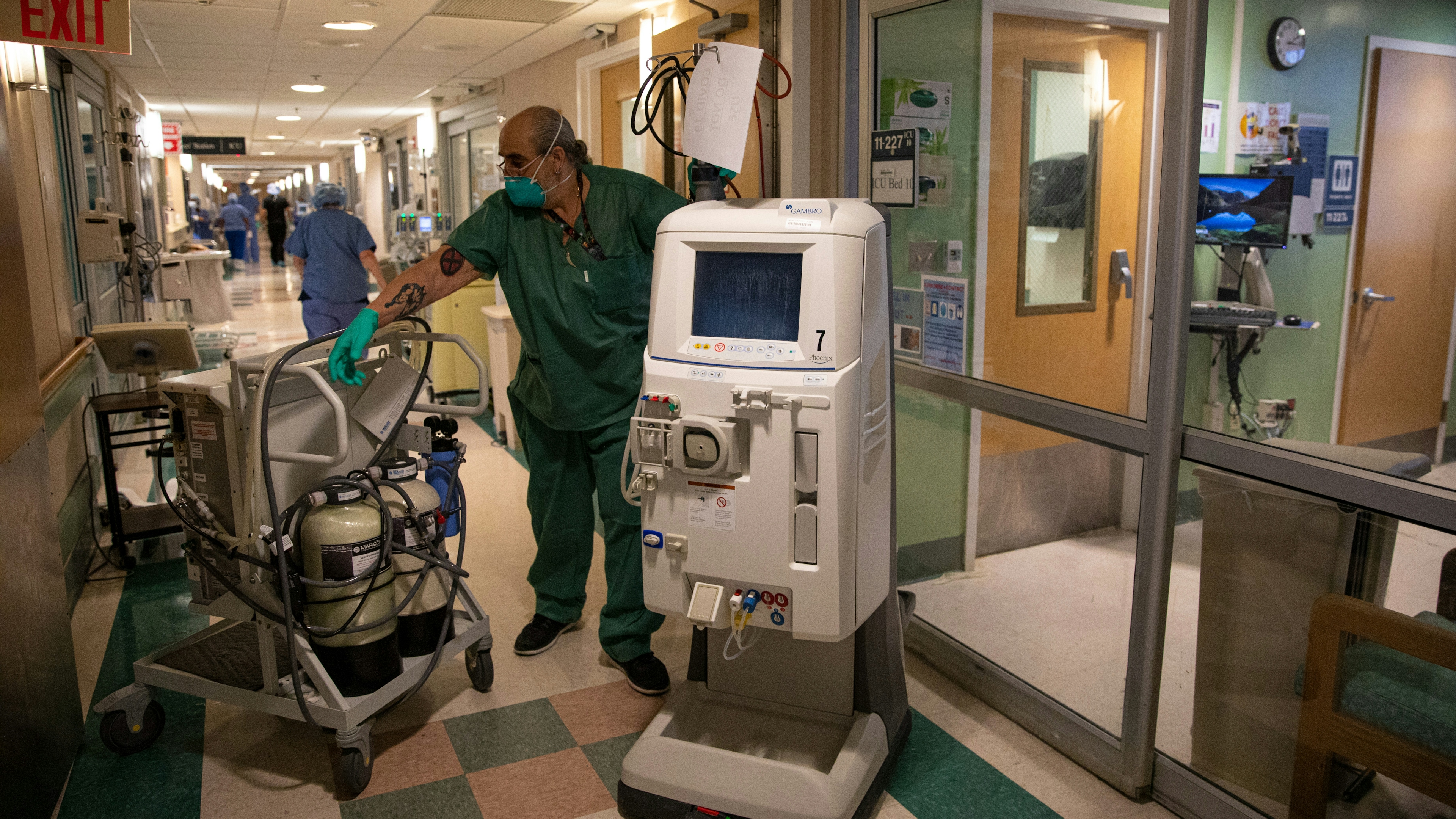 A portable kidney dialysis machine is moved by a hospital staff member 